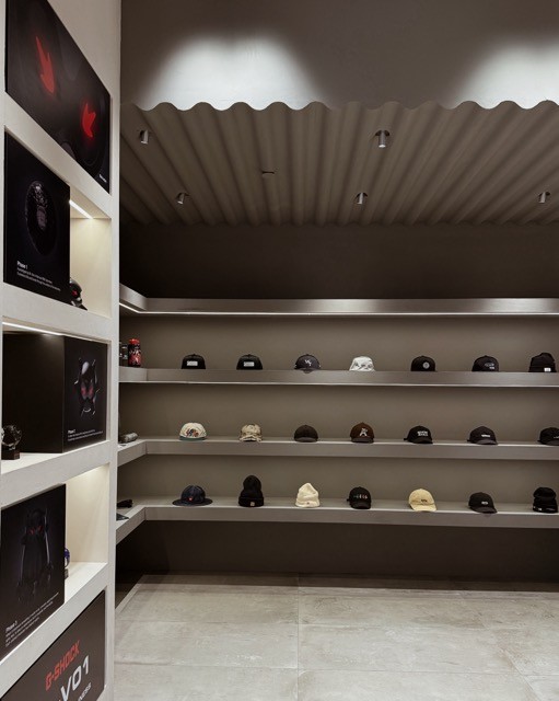 Display of various caps on shelves in a retail store, featuring modern design elements.