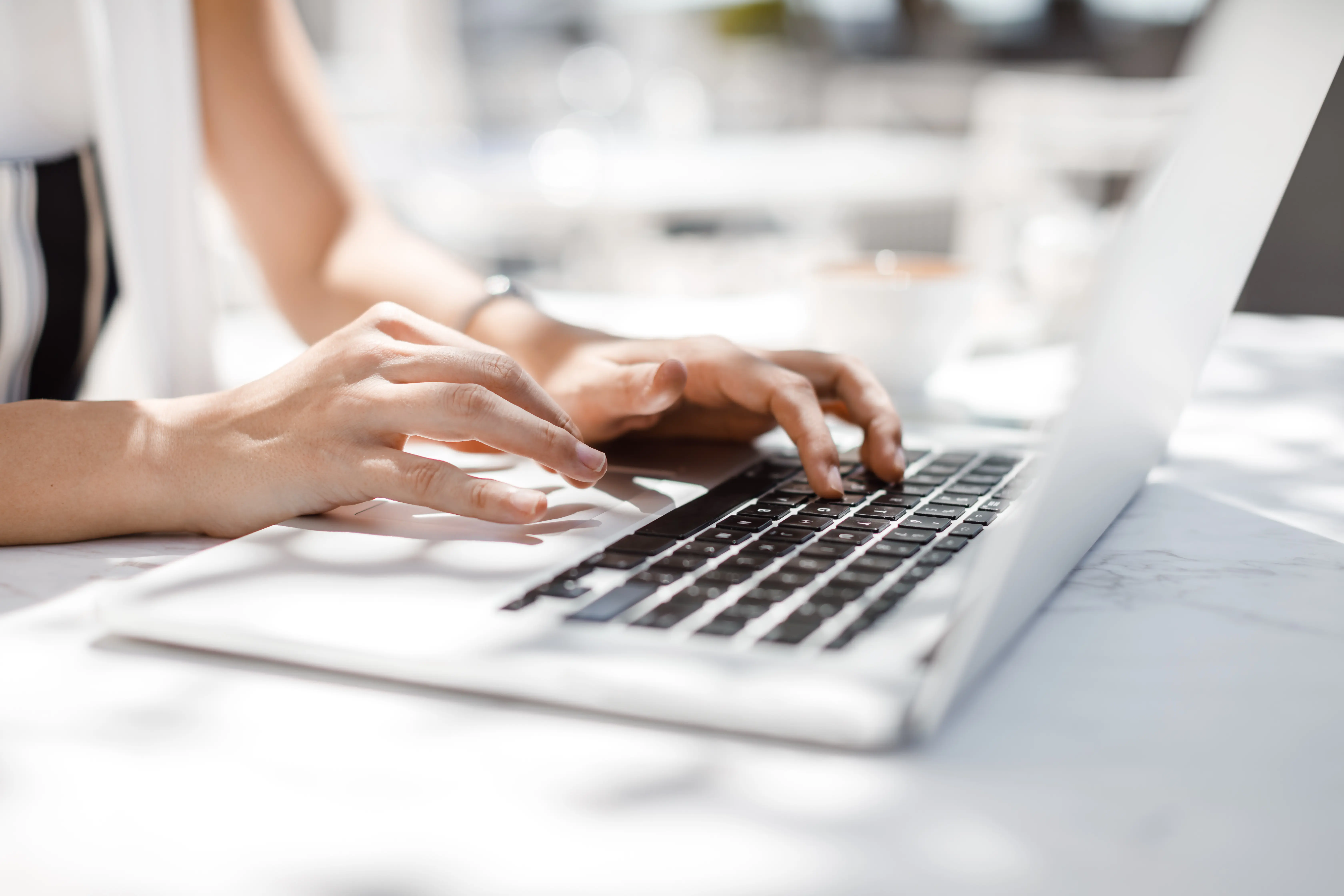 Professional hands typing on a laptop, representing agile support and efficient project-based work at Alberts & Gabriel.