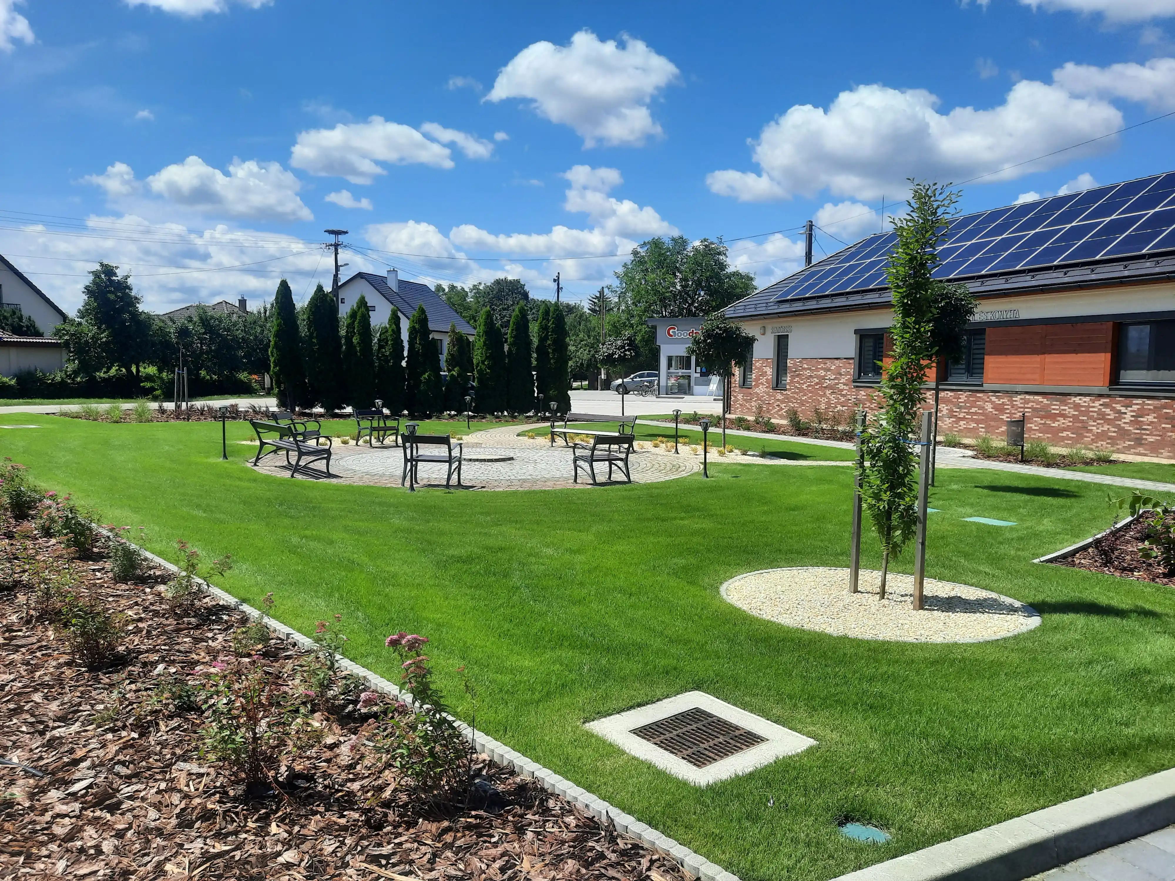 Parkosított közterület emlékmű pihenőpaddal és sziklakerttel