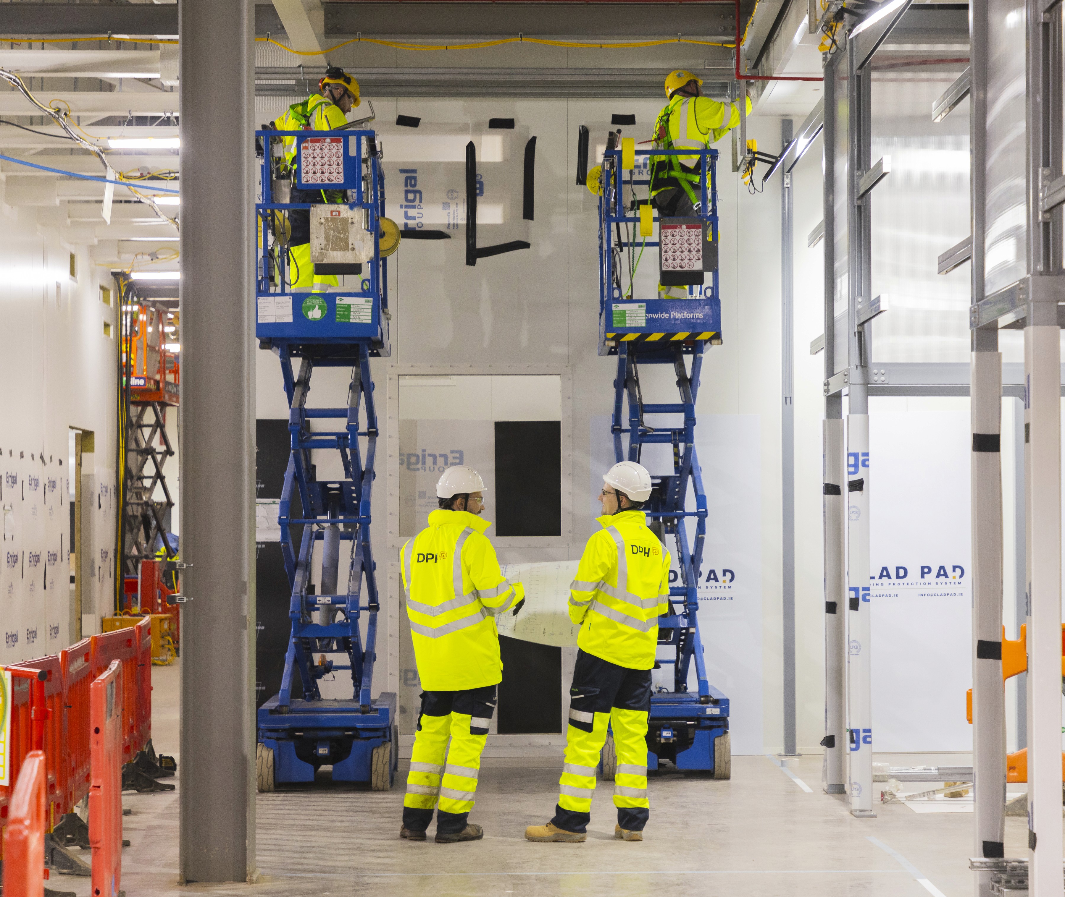 Modern glass buildings with illuminated facades and trees on a rainy day