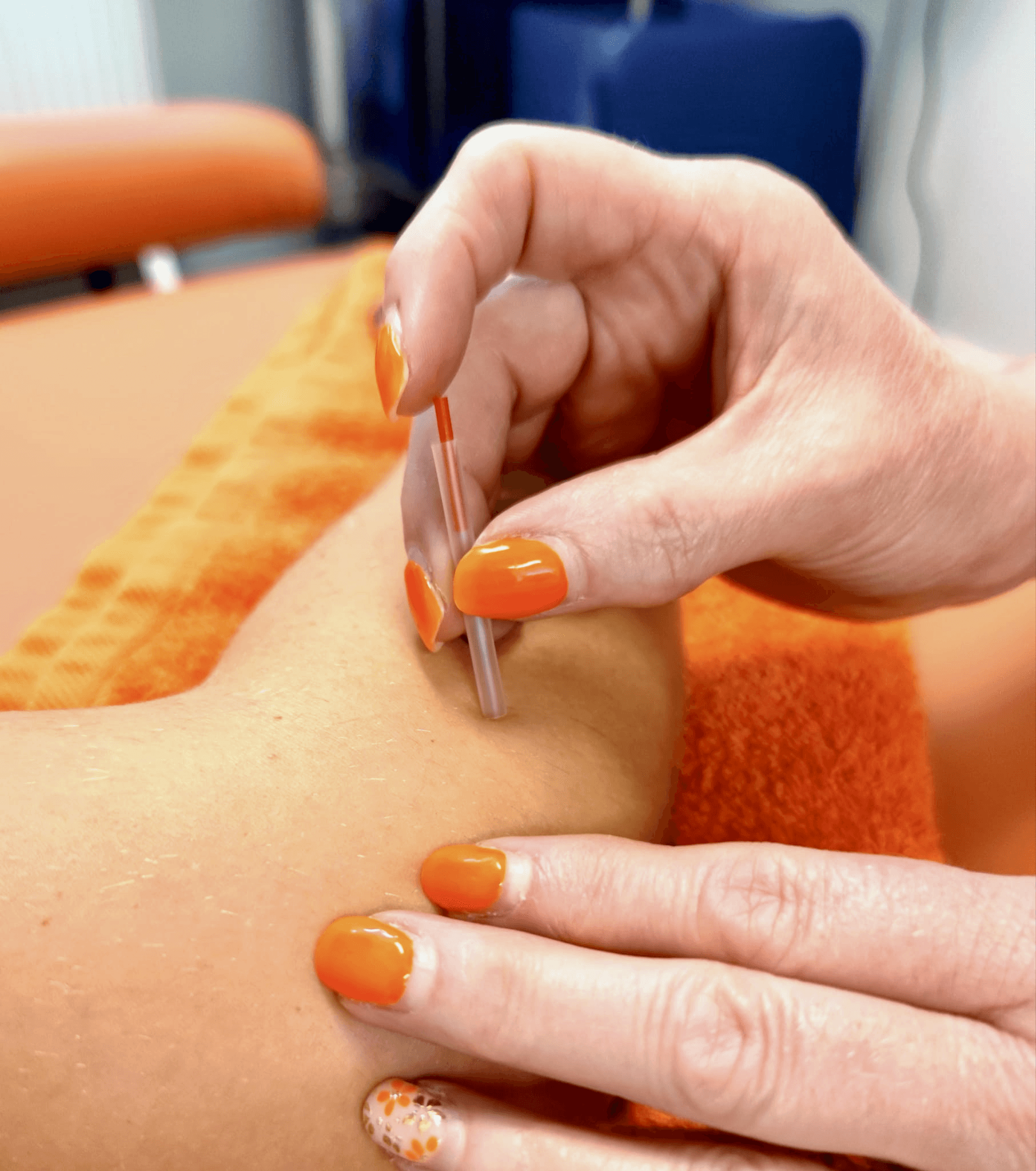 Close up of hot stones on orange towels ready for a massage.