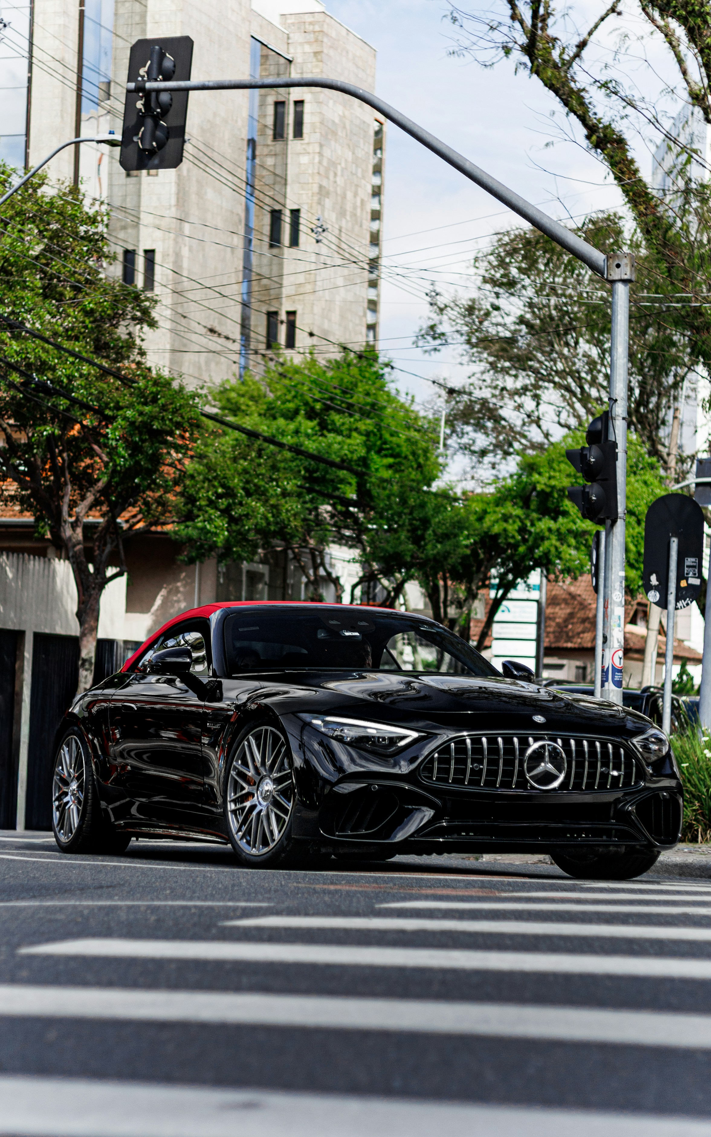 Black convertible mercedes-benz parked at a crosswalk.