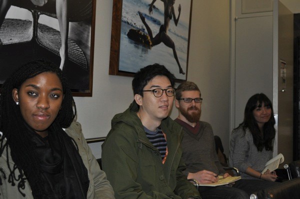 A photo of a group of people taking notes and listening to a lecture.