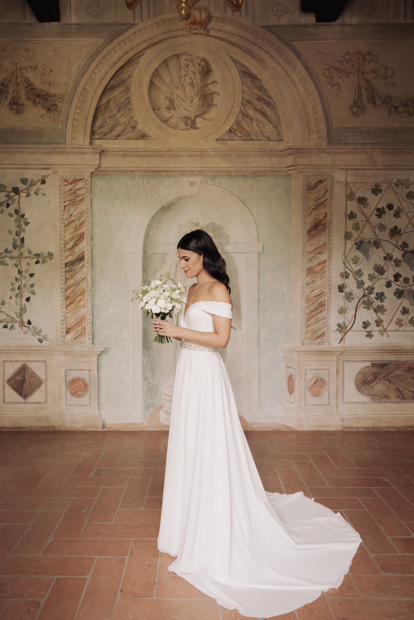 Sposa in abito bianco con bouquet tra gli archi affrescati di Villa Negri, reportage matrimoniale Fotolize