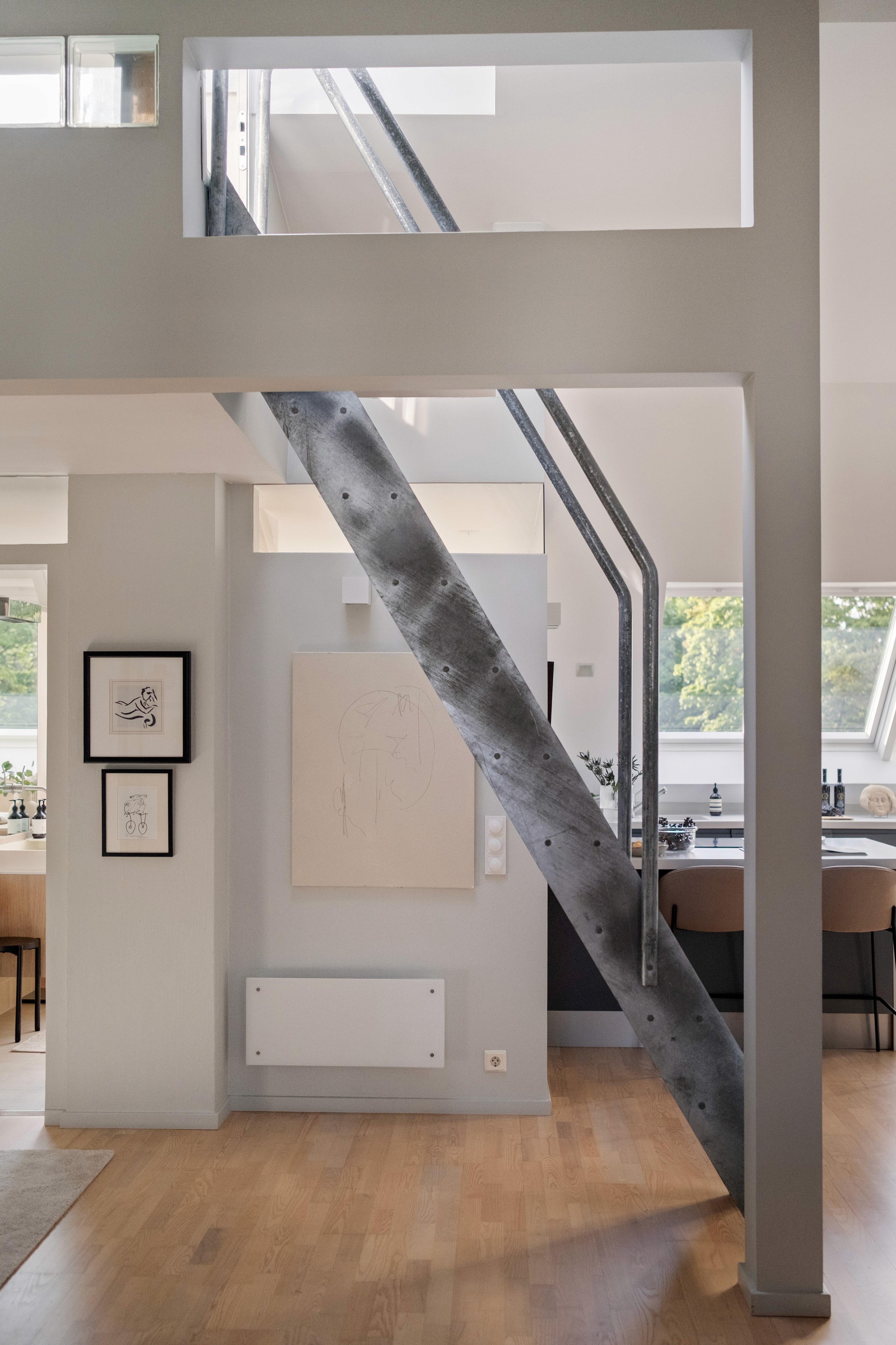 Interiør med moderne trapp, tregulv og kunst på veggen