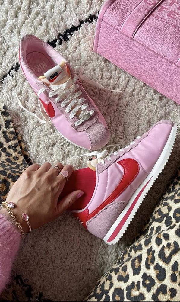 Smiling man with glasses giving a thumbs up while seated at a laptop in natural light
