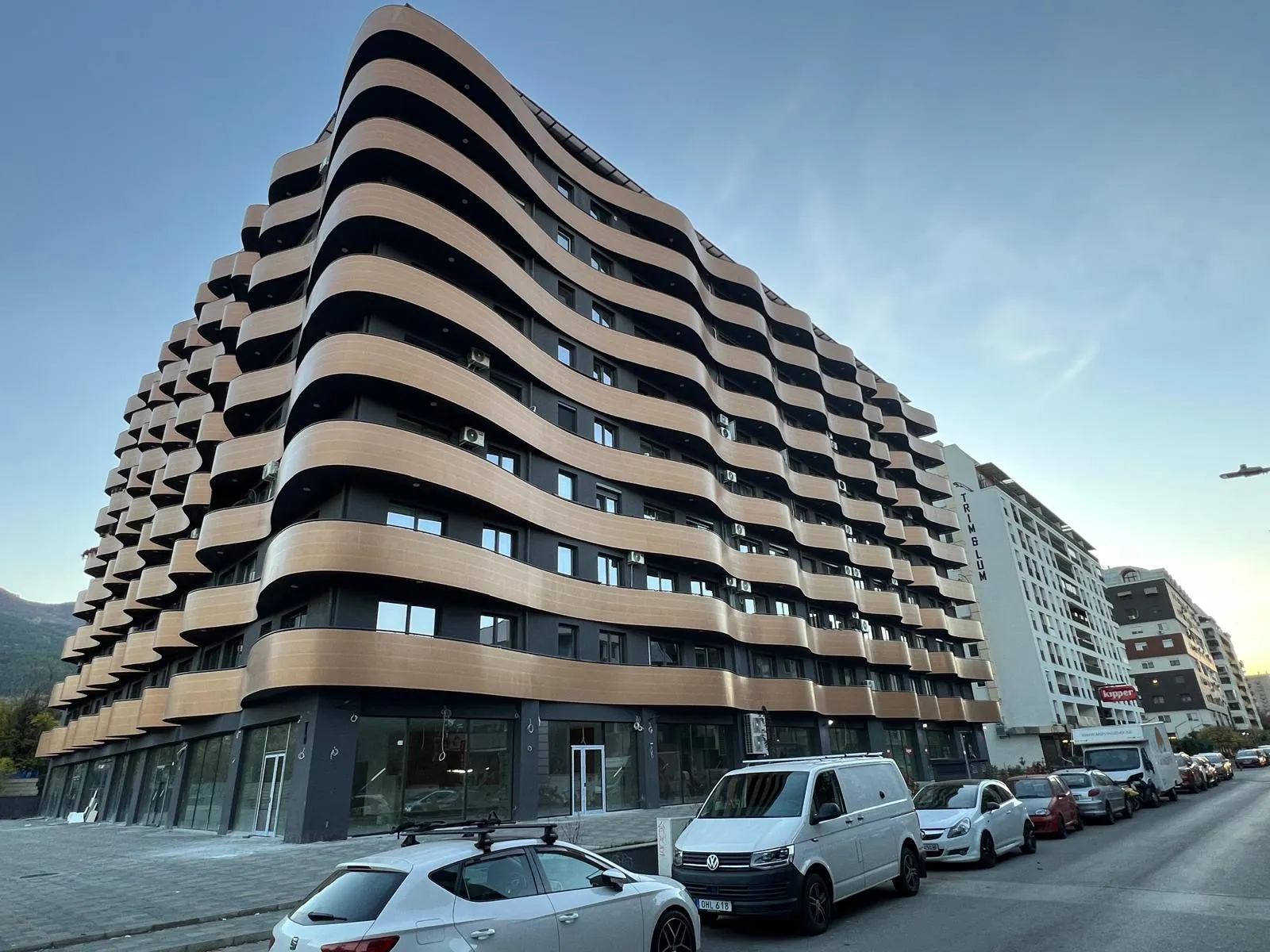Residential building in Skopje with dynamic curved façade elements and dark exterior detailing, supervised by Terraplan Partners.