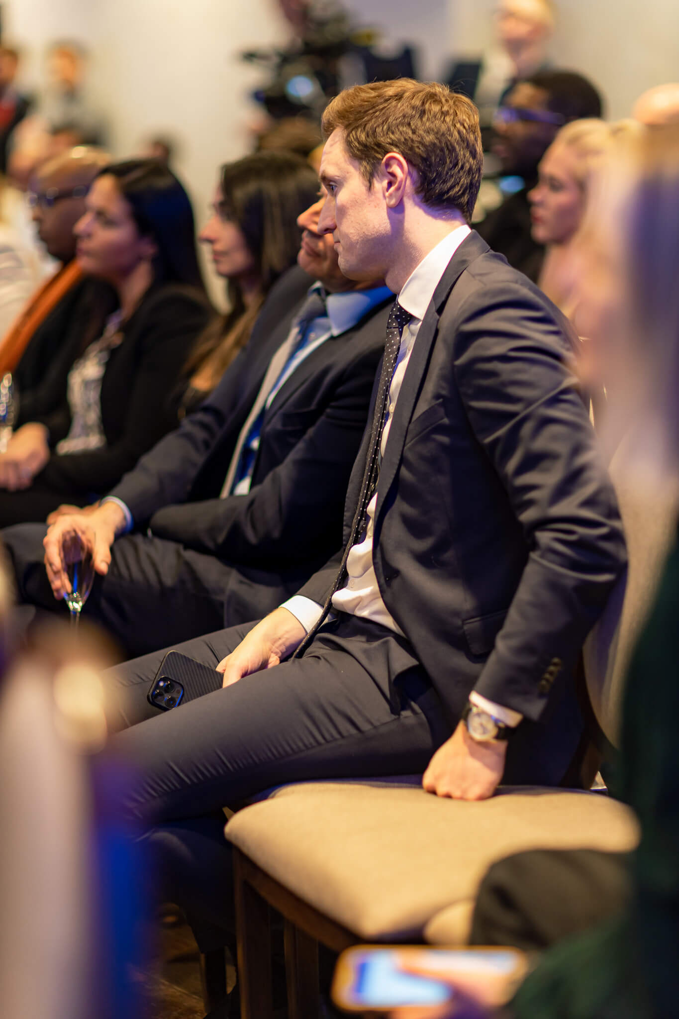 Business professional listening during a finance conference and networking event