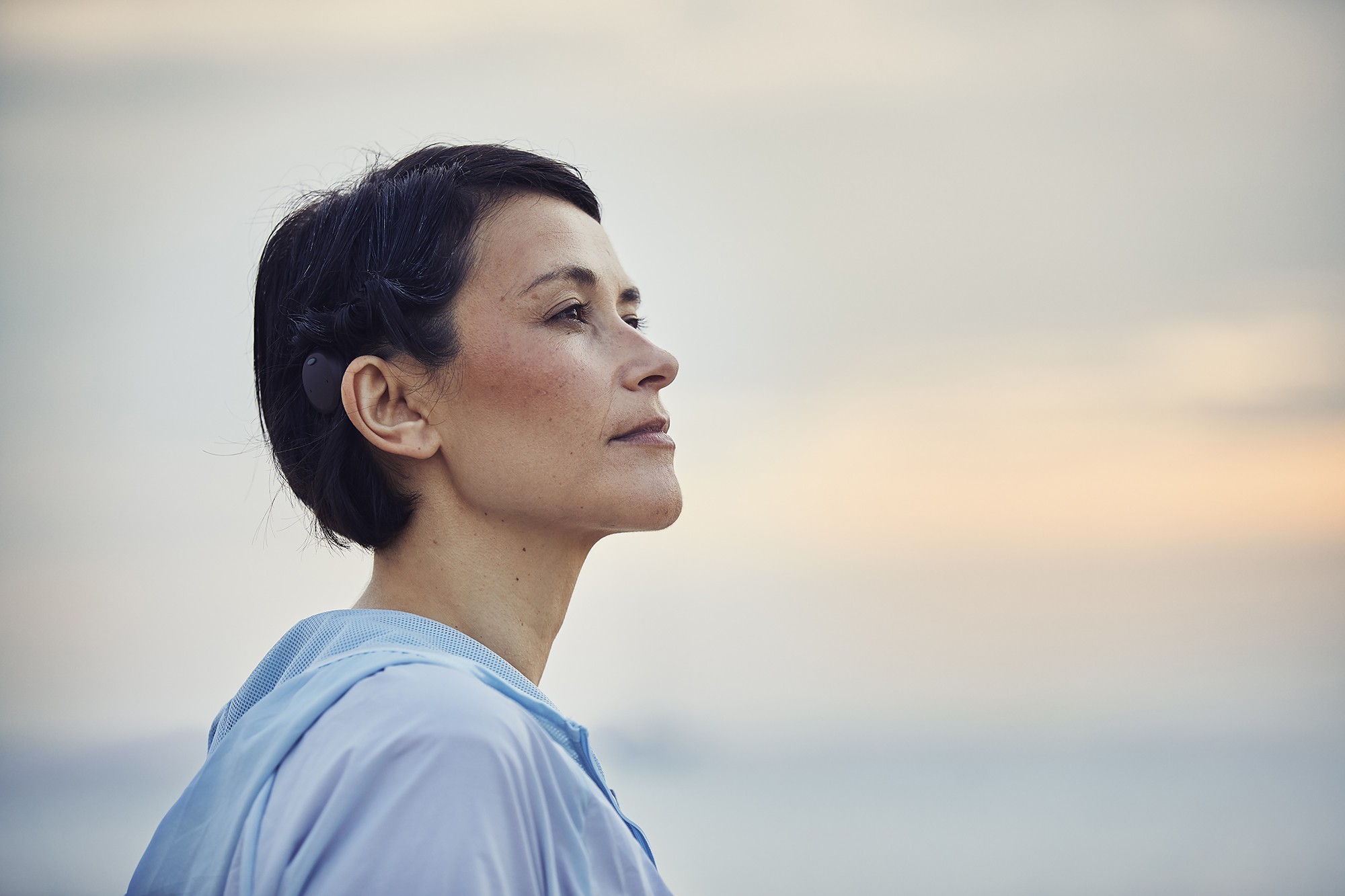 A young woman wearing a cochlear implant device