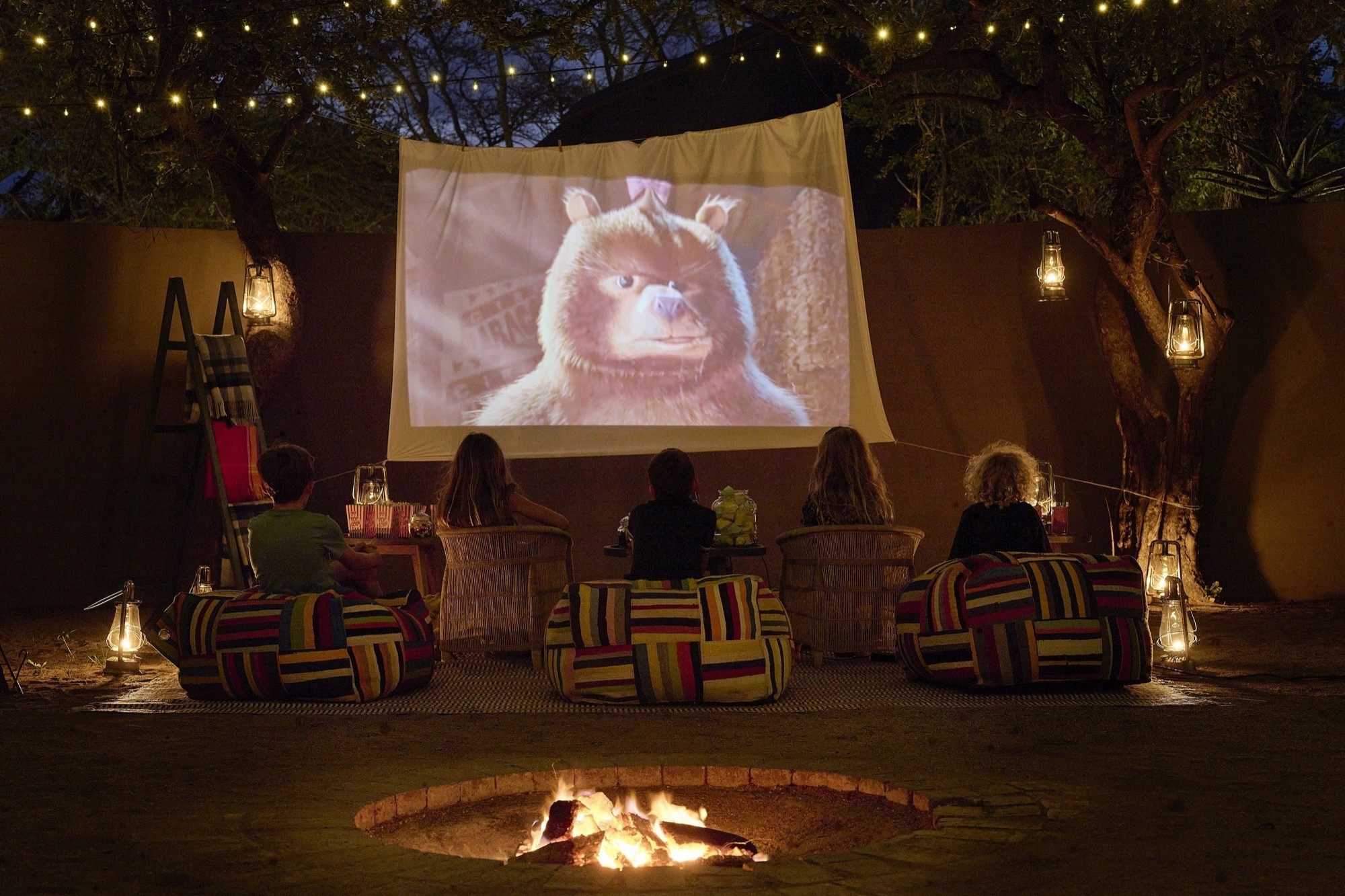 Children at an outdoor movie night around the boma fire