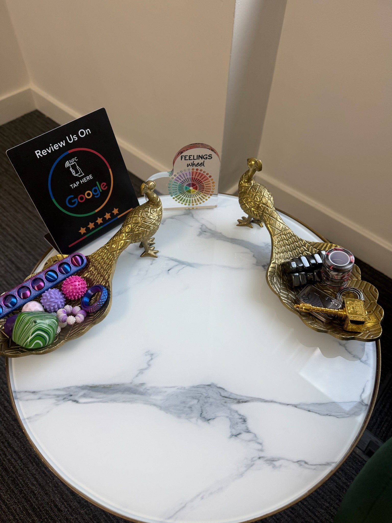 Side table with sensory objects and a feelings wheel in the Core Psychotherapy room