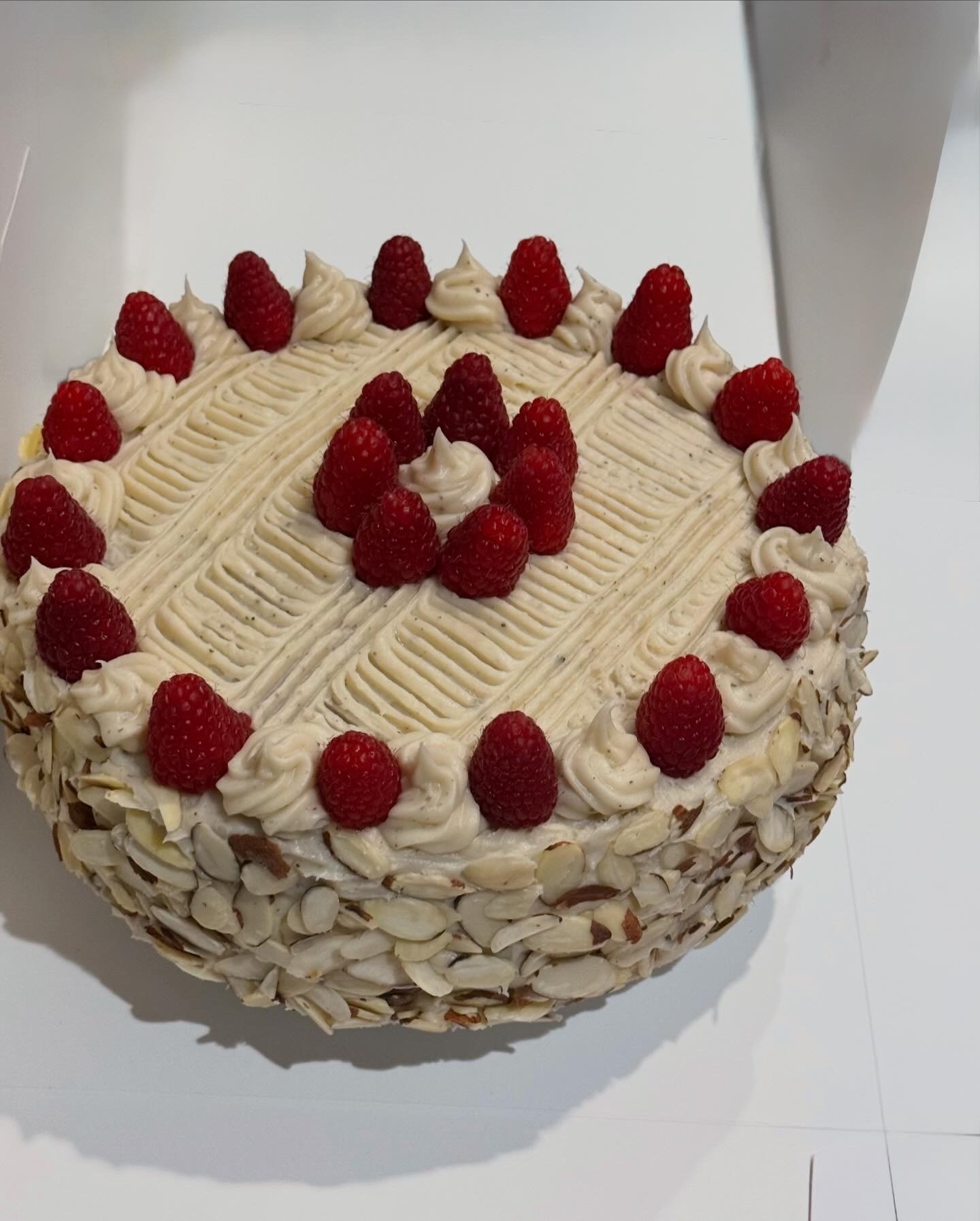 Earl Grey Rasberry Vanilla Cake with rasberries on top and almonds on the sides