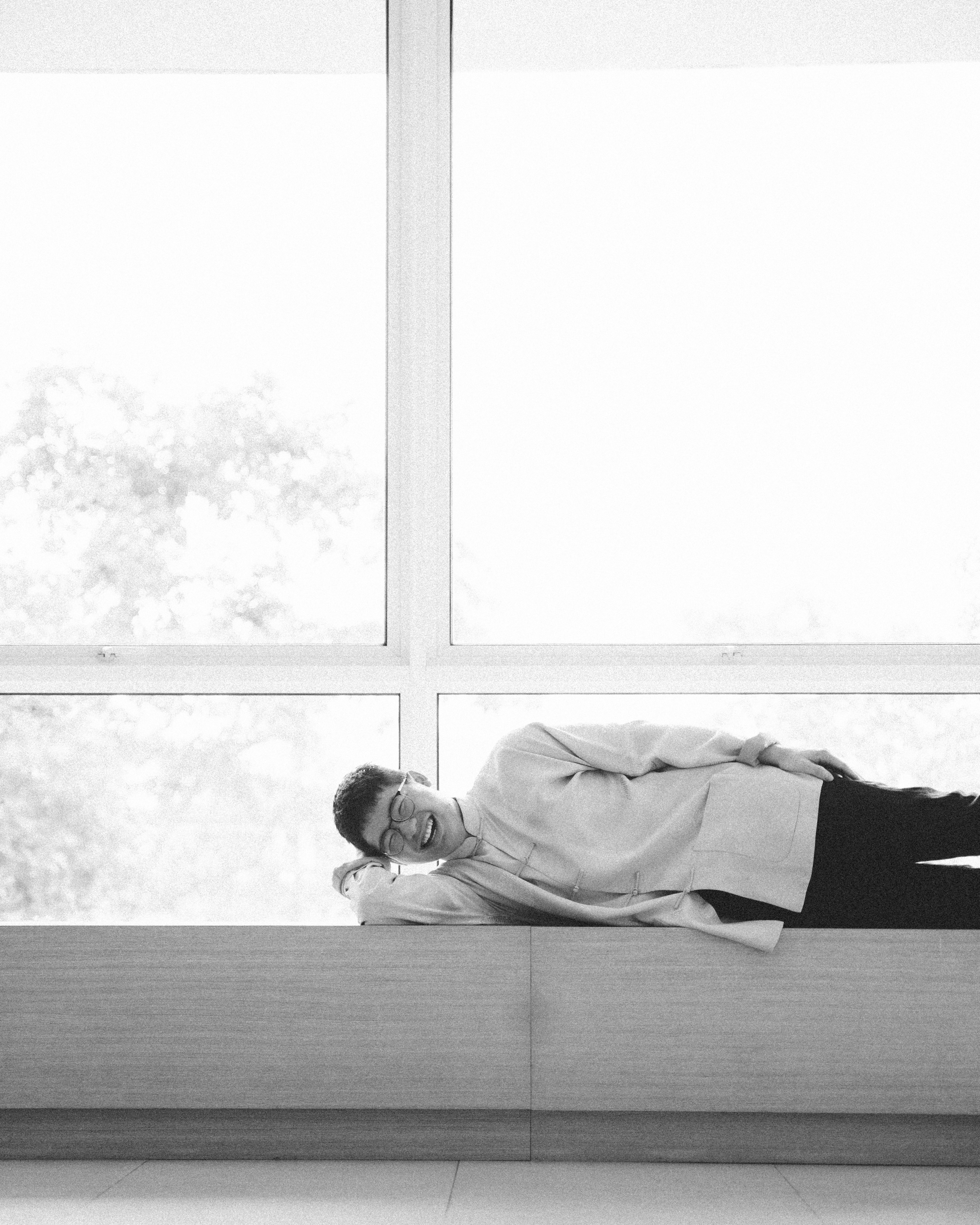 Man poses, funny lying down on seats black and white photo