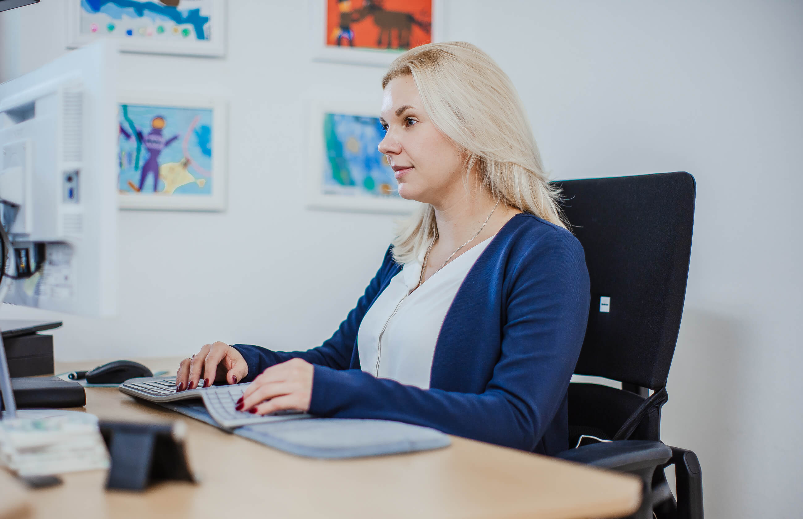 Theresa sitzt konzentriert an ihrem Schreibtisch in ihrem hellen Büro, bereit zur HR-Copywriting und Employer Branding Beratung für kleine Unternehmen