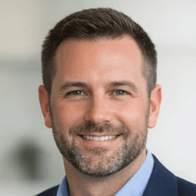 A man standing in front of a window smiling