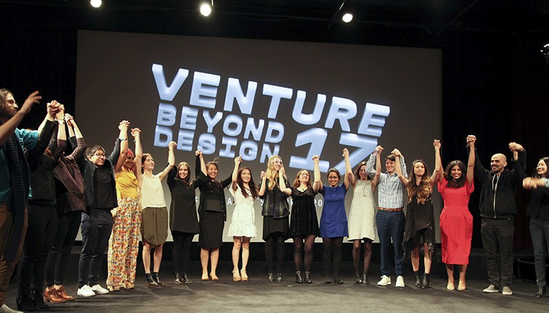 a group photo of people with hands raised in the air