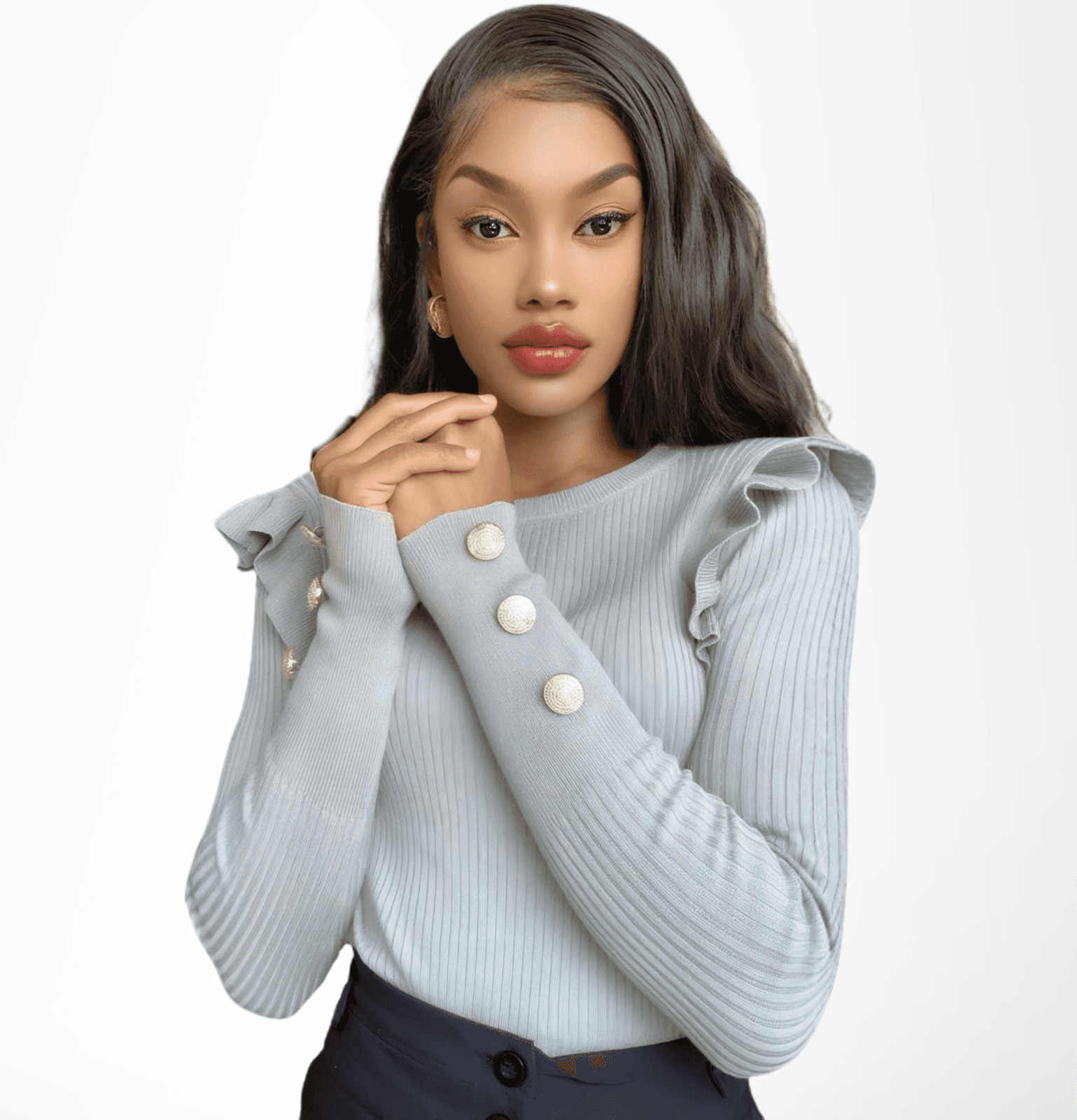 A woman in a gray sweater and black pants stands confidently, representing leadership in faith and community engagement.