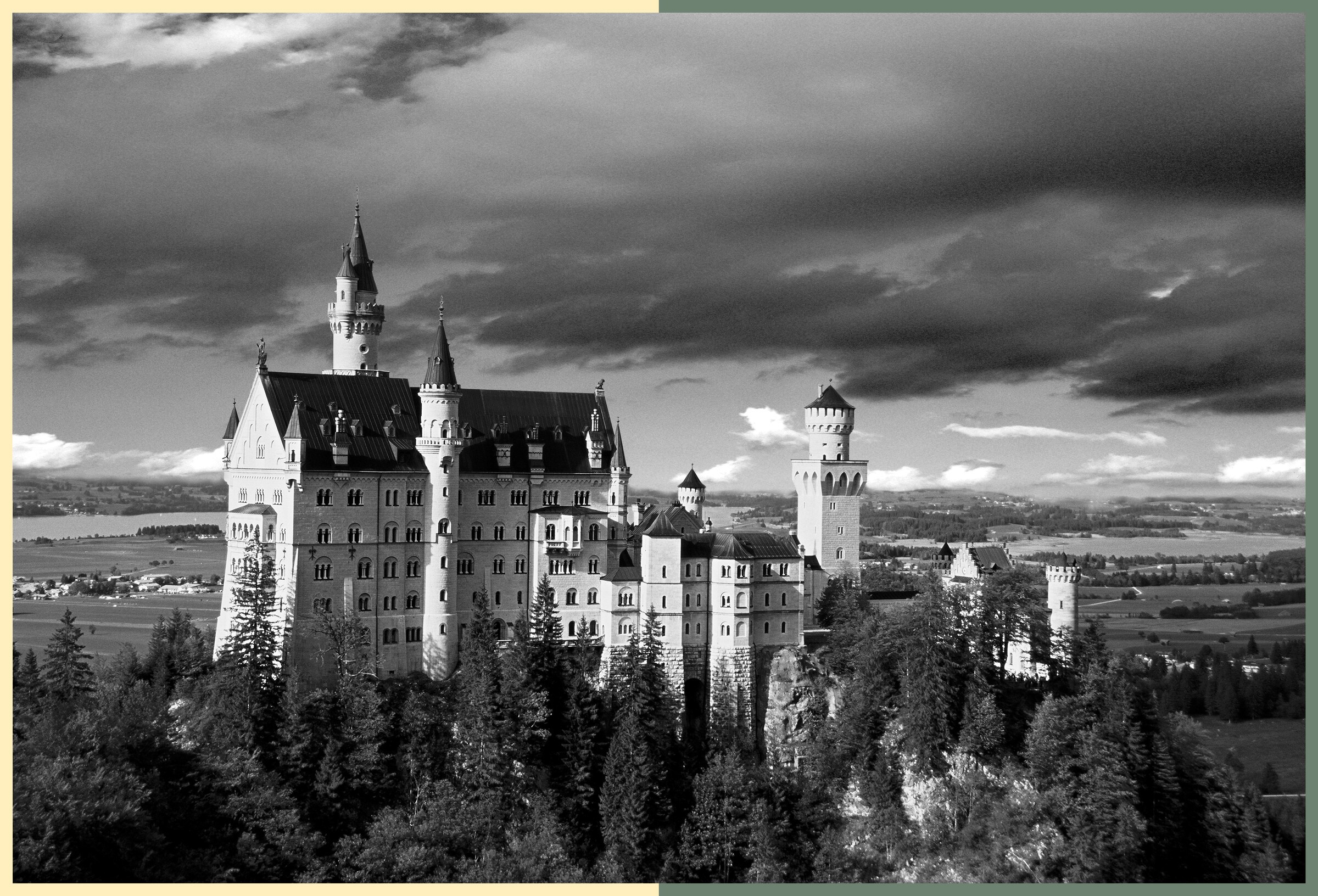 Schloss Neuschwanstein über dem Wald, Seen im Hintergrund, schwarz-weiß mit Farbrahmen