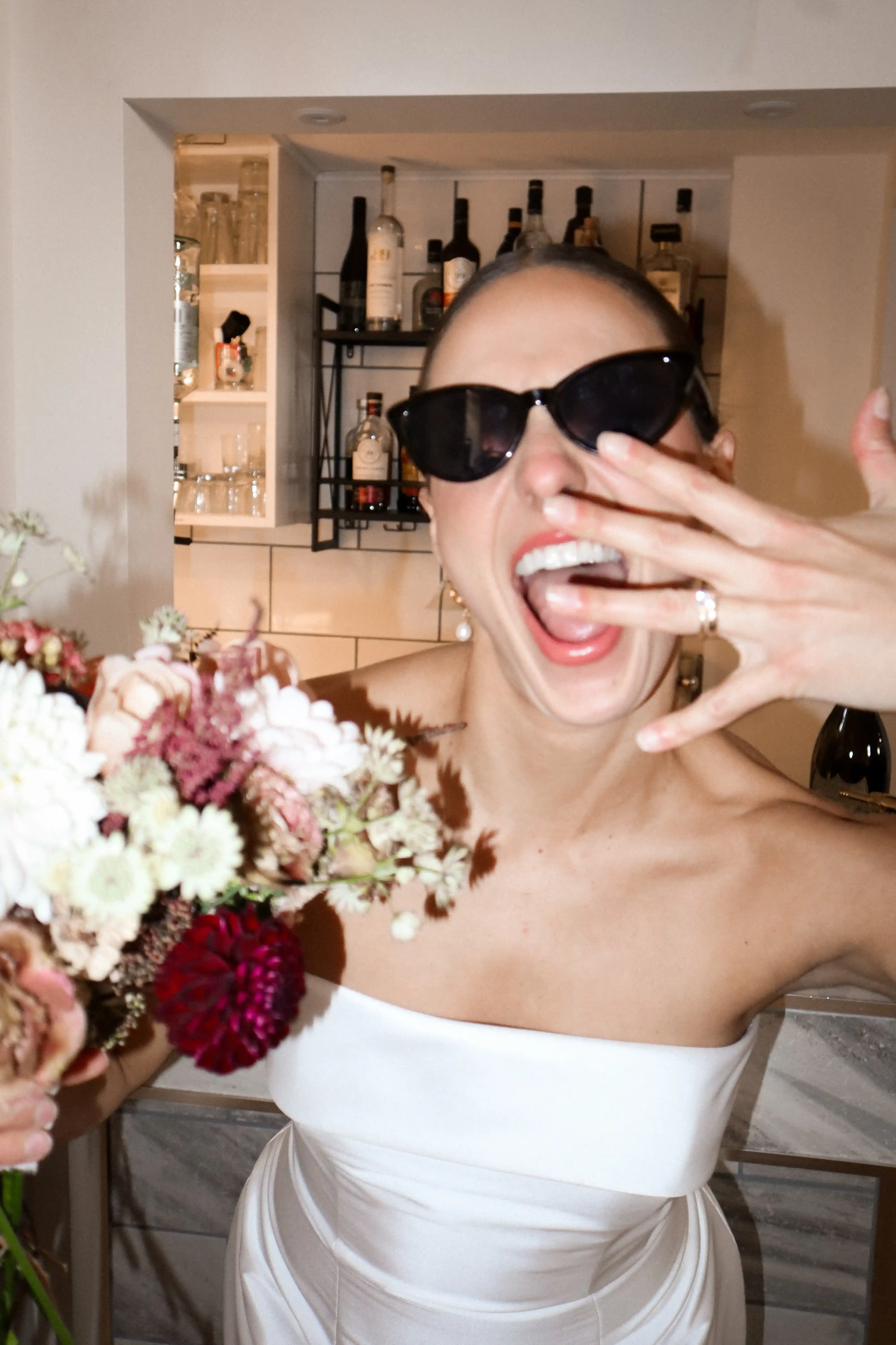 Bride celebrating with bouquet at the cocktail bar inside Ashlar Ottawa
