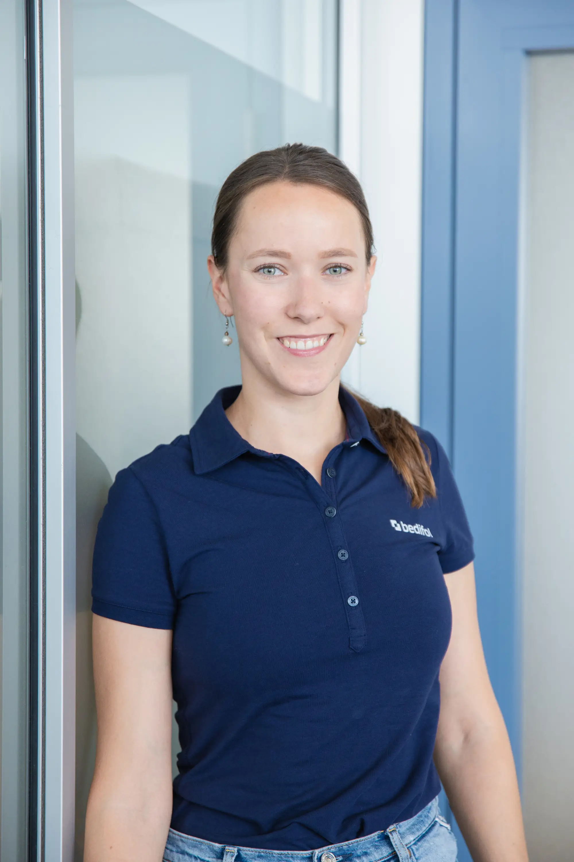 A woman in a dark blue Bedifol polo shirt.