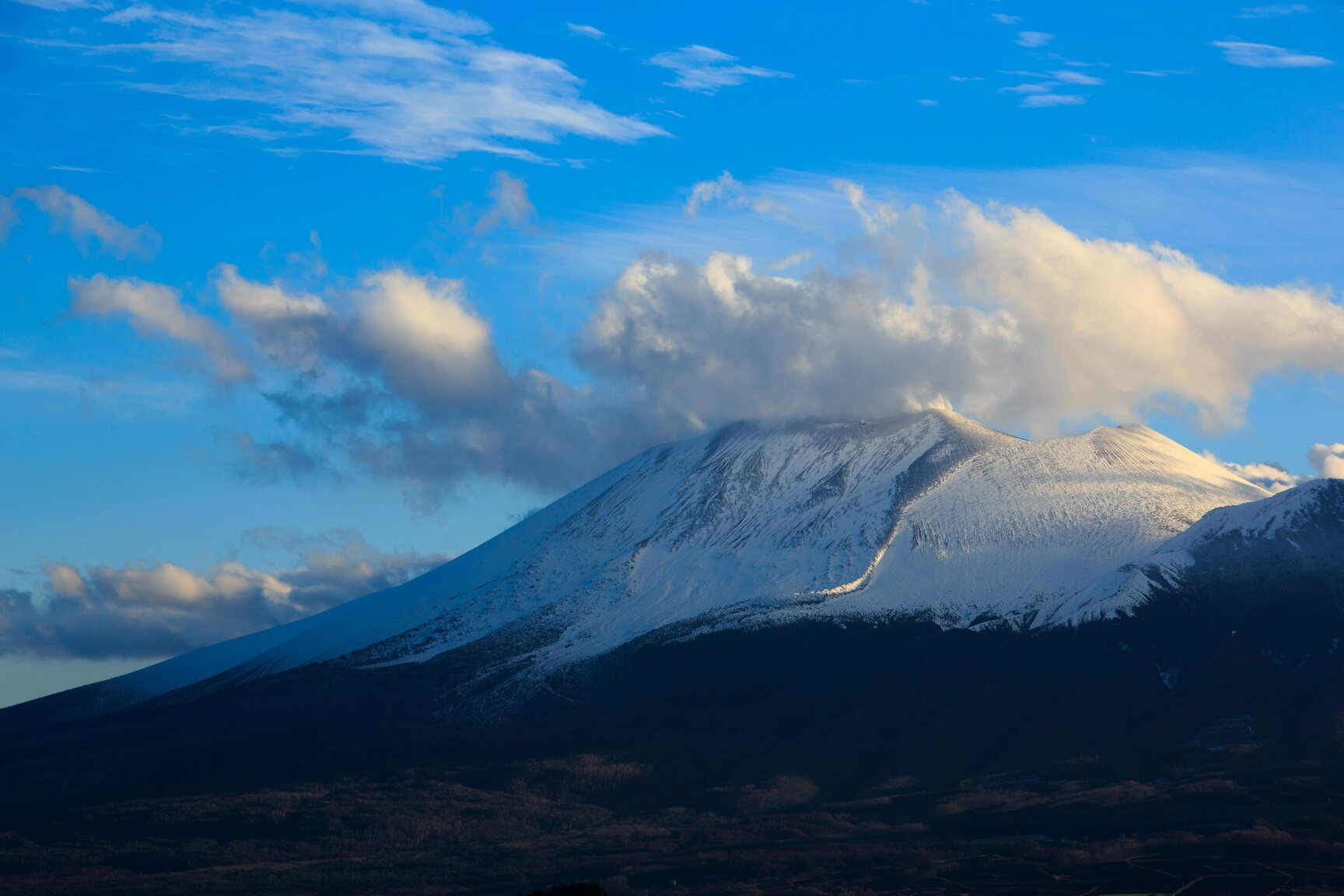 Snow covered mountain under blue sky