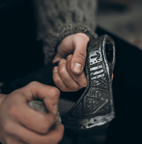 eine Hand hält eine Lupe und vergrößert eine alte hebräische Schrift