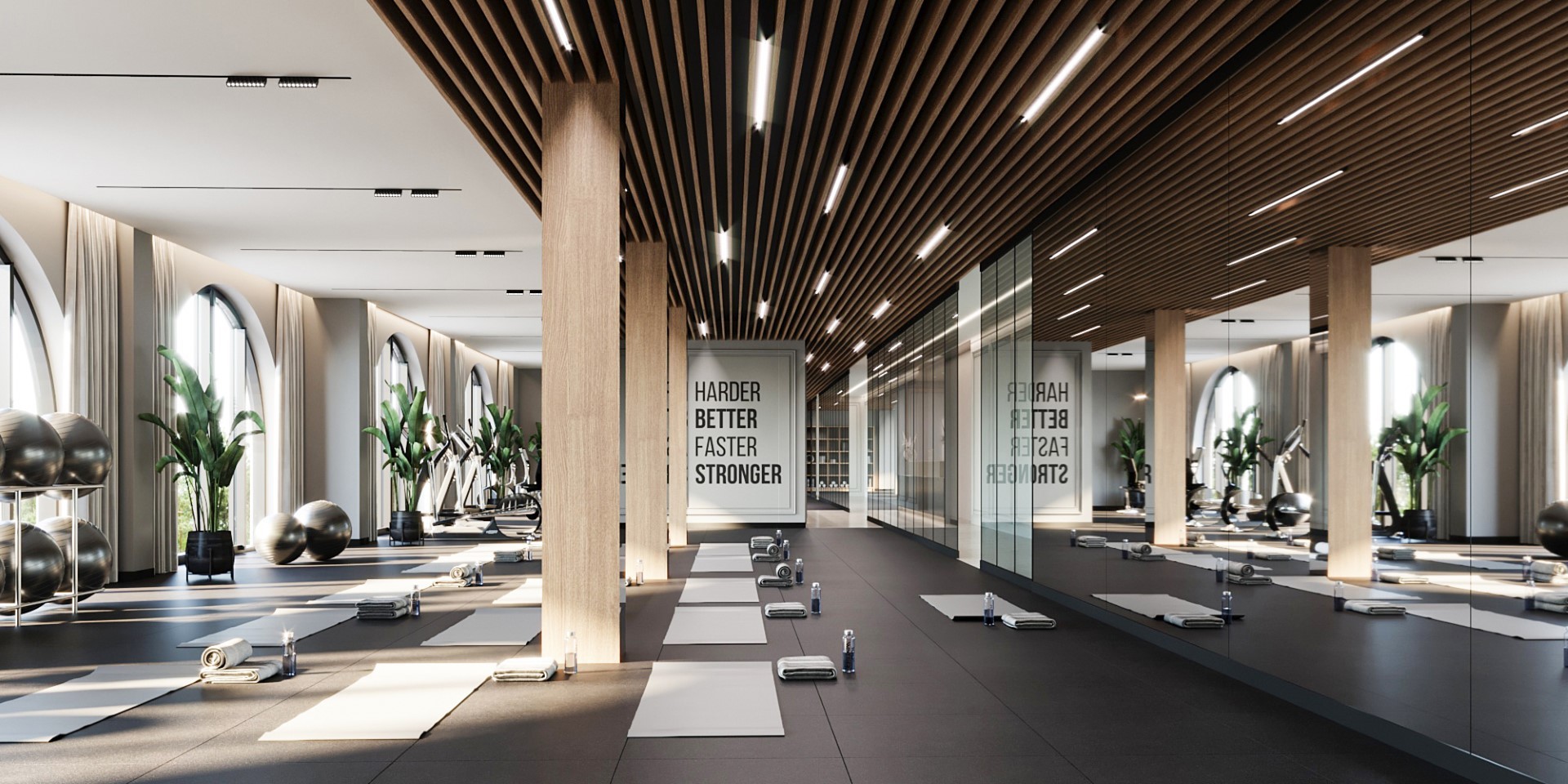 Spacious, modern yoga studio with large windows, wooden elements, yoga mats, mirrored walls, and motivational quotes, designed for fitness enthusiasts.