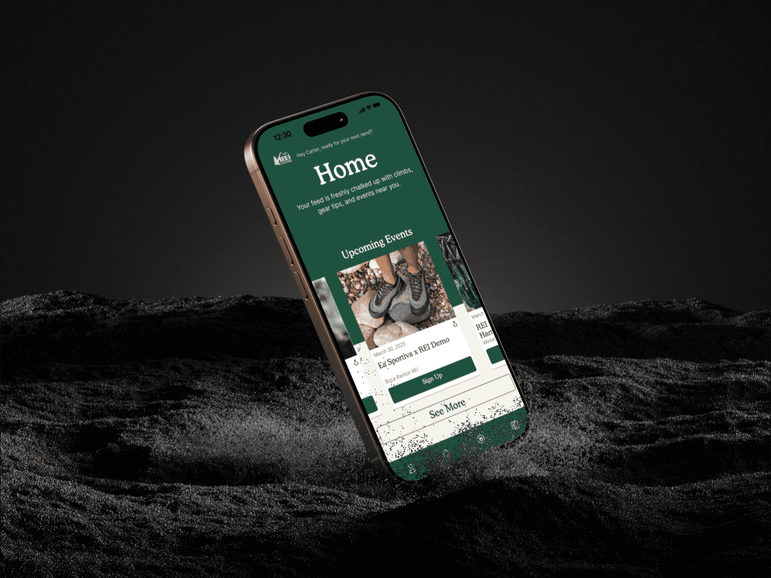 Phone being dropped in black sand while displaying an green homepage of an app