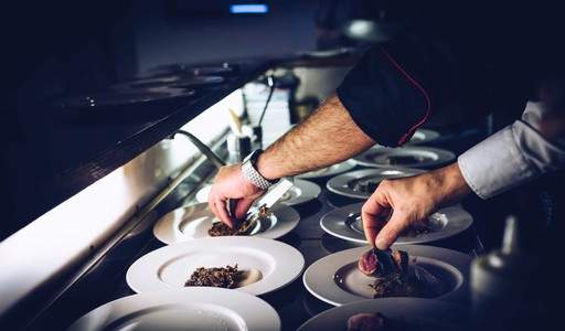 Foto de dos chefs de restaurante preparando los platos de comida