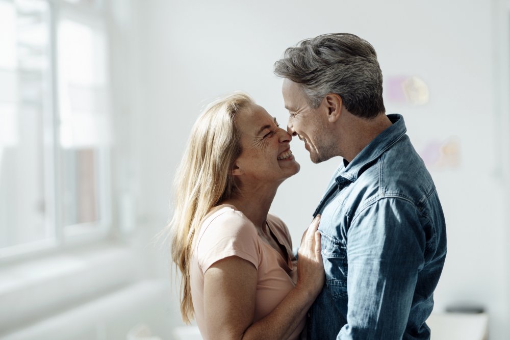 man in blue polo shirt carrying girl in white and pink floral dress