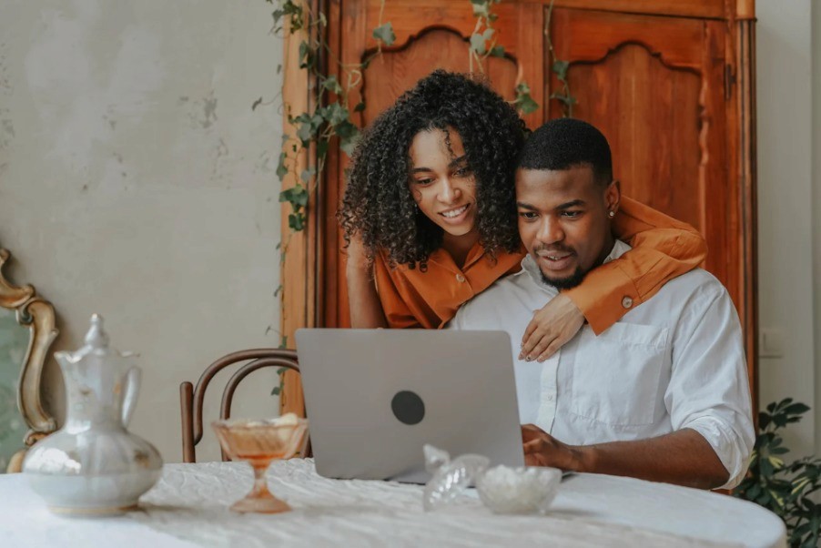 Pareja revisando un computador para planificar ahorro en conjunto