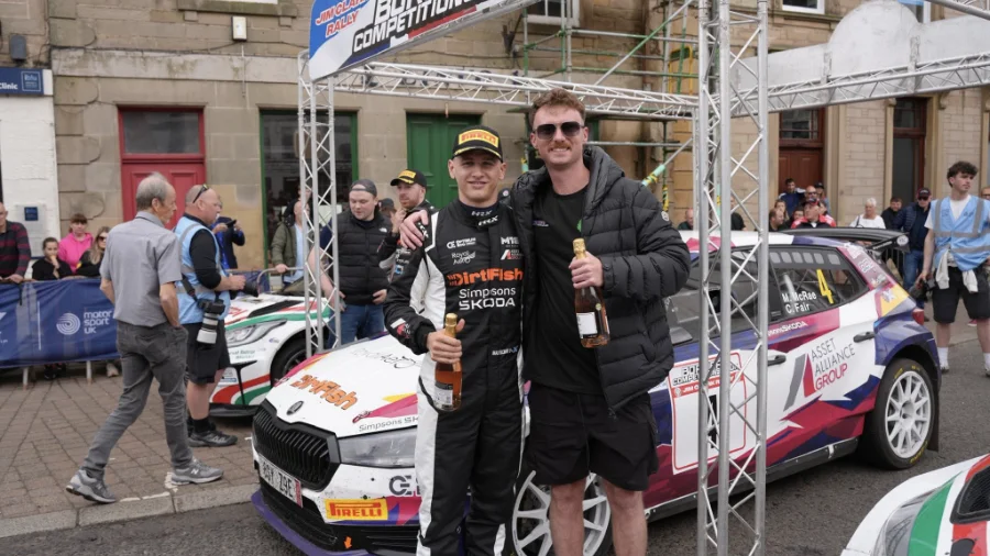 Jack Crowe stands with rally driver Callum Devine in front of a Škoda rally car at the Jim Clark Rally.