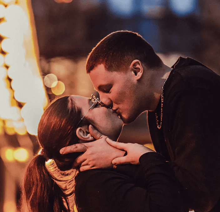 Couple qui s'embrasse à la nuit tombé sous les lumières