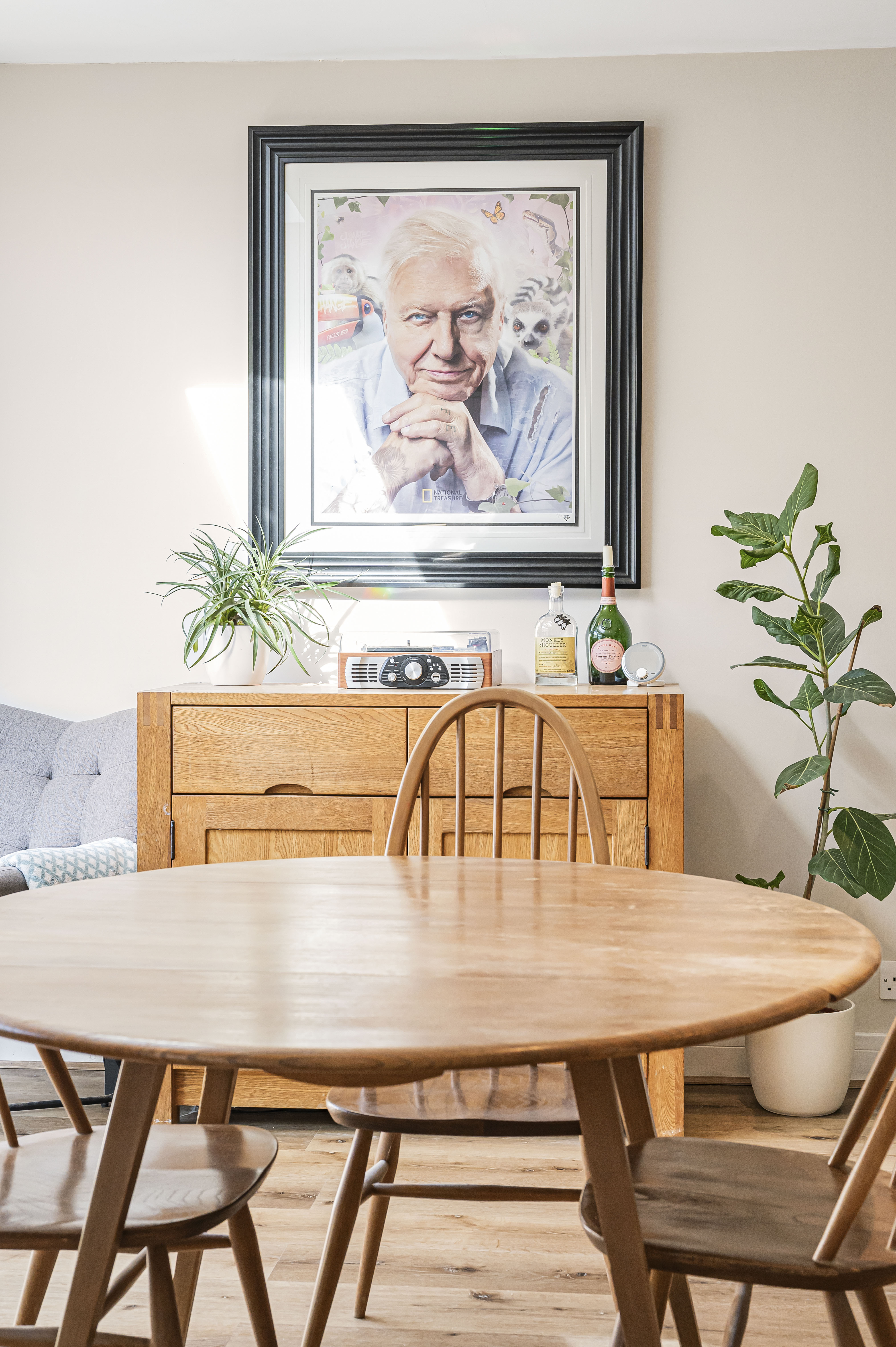 A couple in formal attire walking hand-in-hand, smiling, in an elegant outdoor setting. The woman wears a hijab.