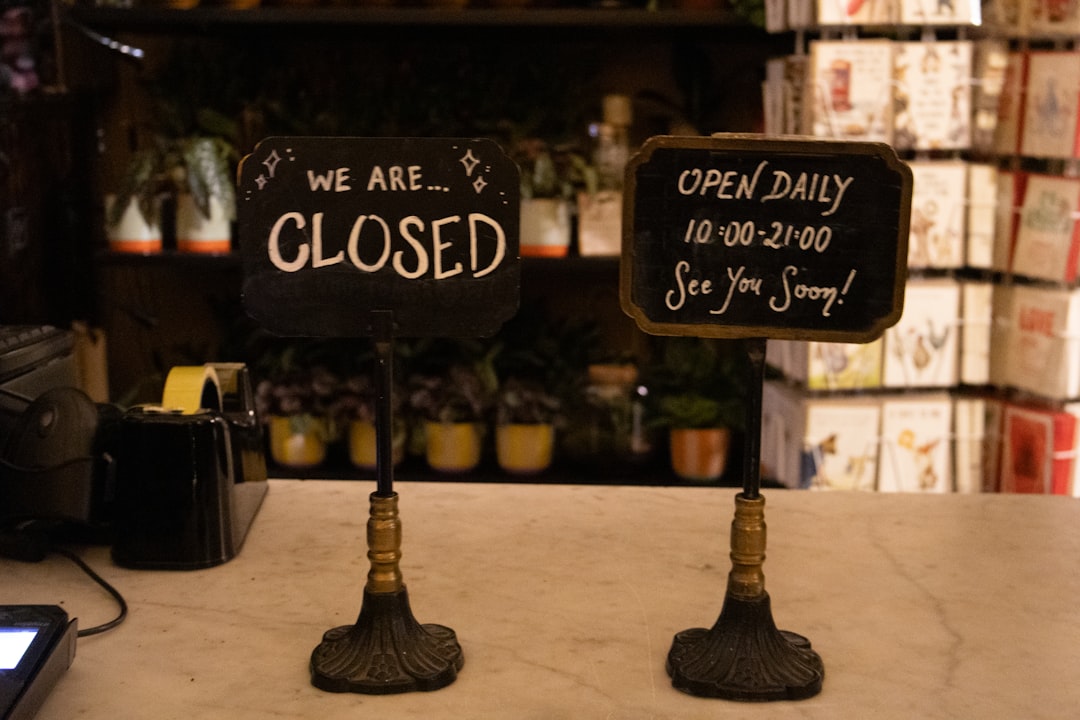 Two signs, one closed, one open daily.