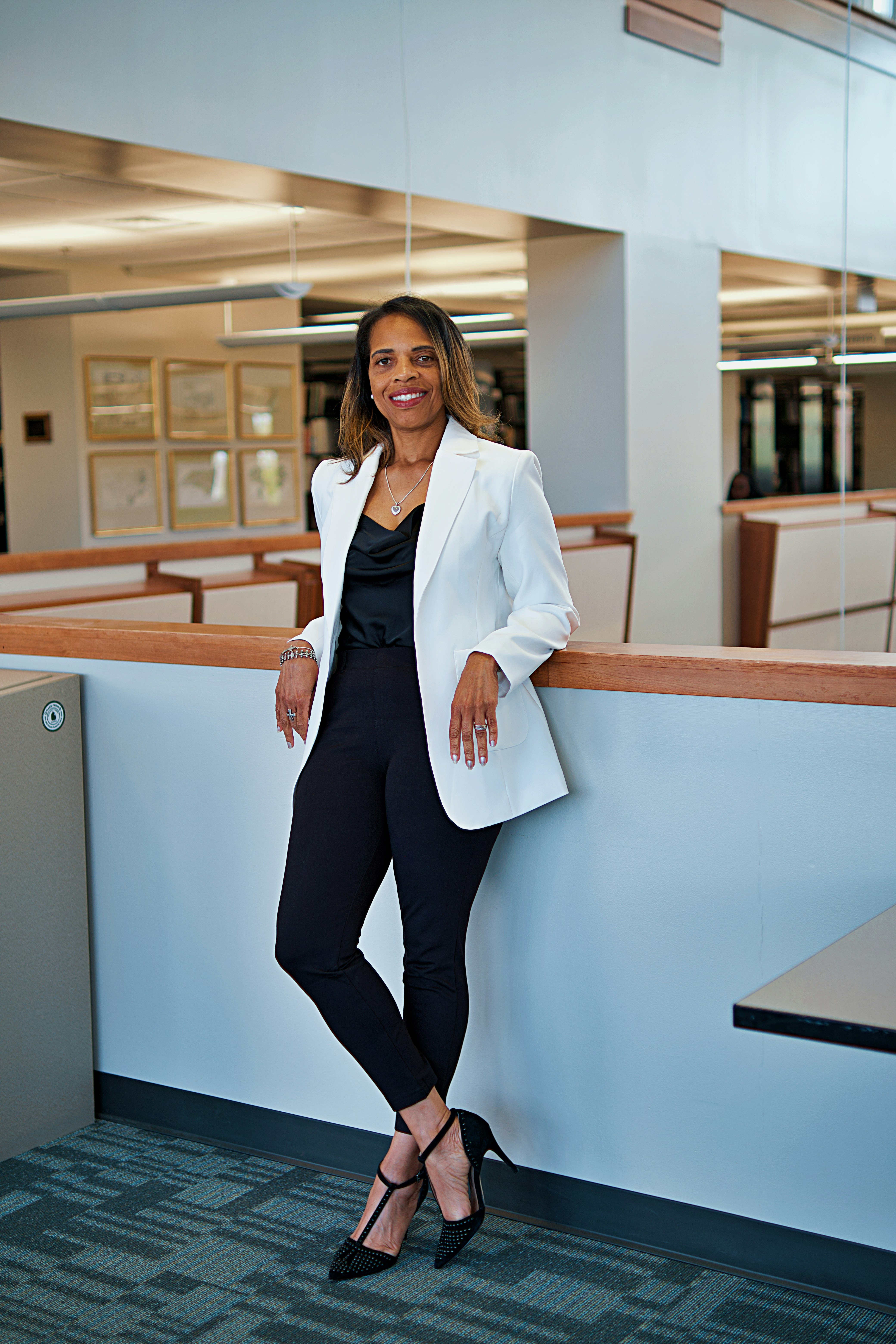 A woman leaning against a wall in an office