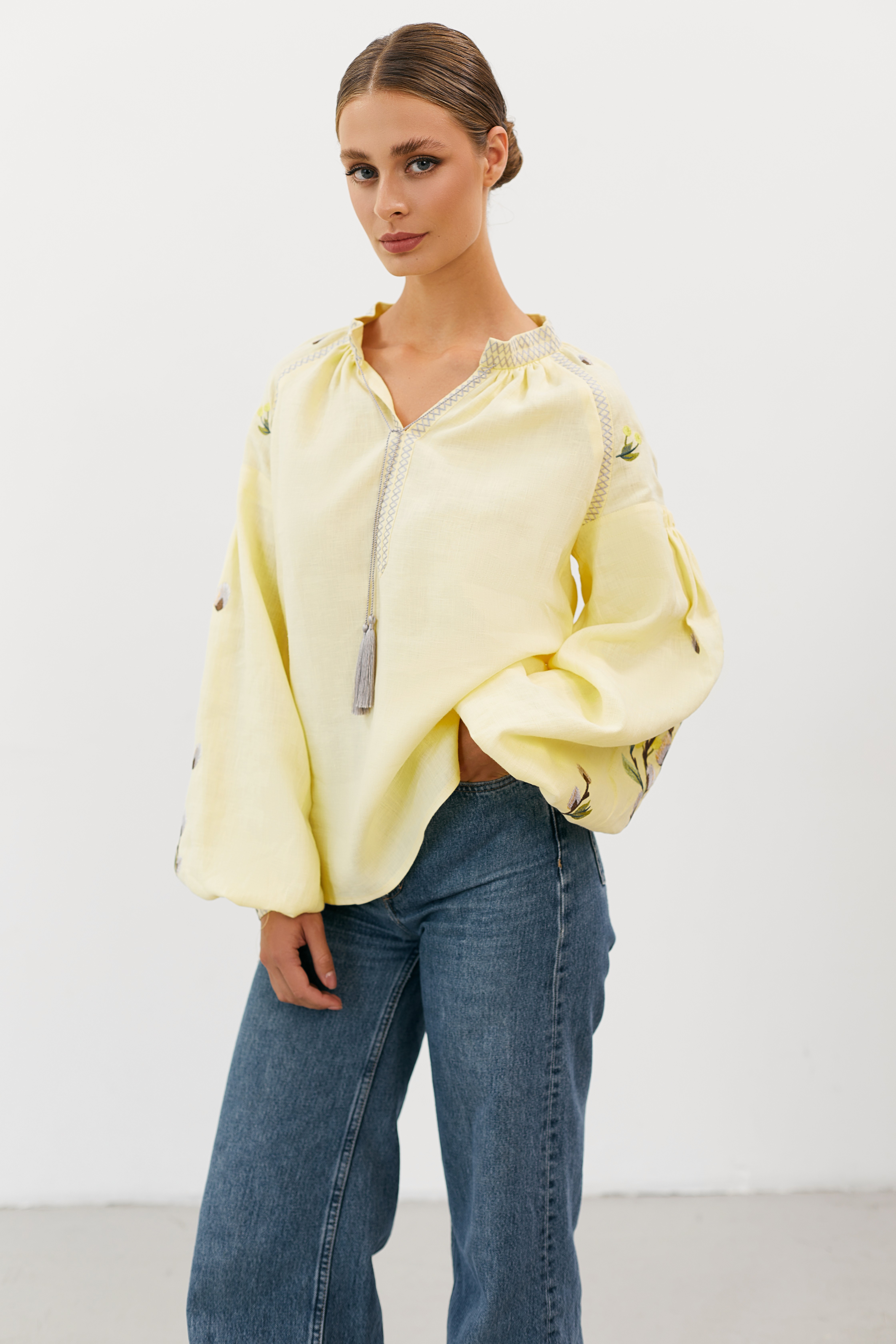 Woman wearing layered crimson and gold necklaces, posing against a deep red background