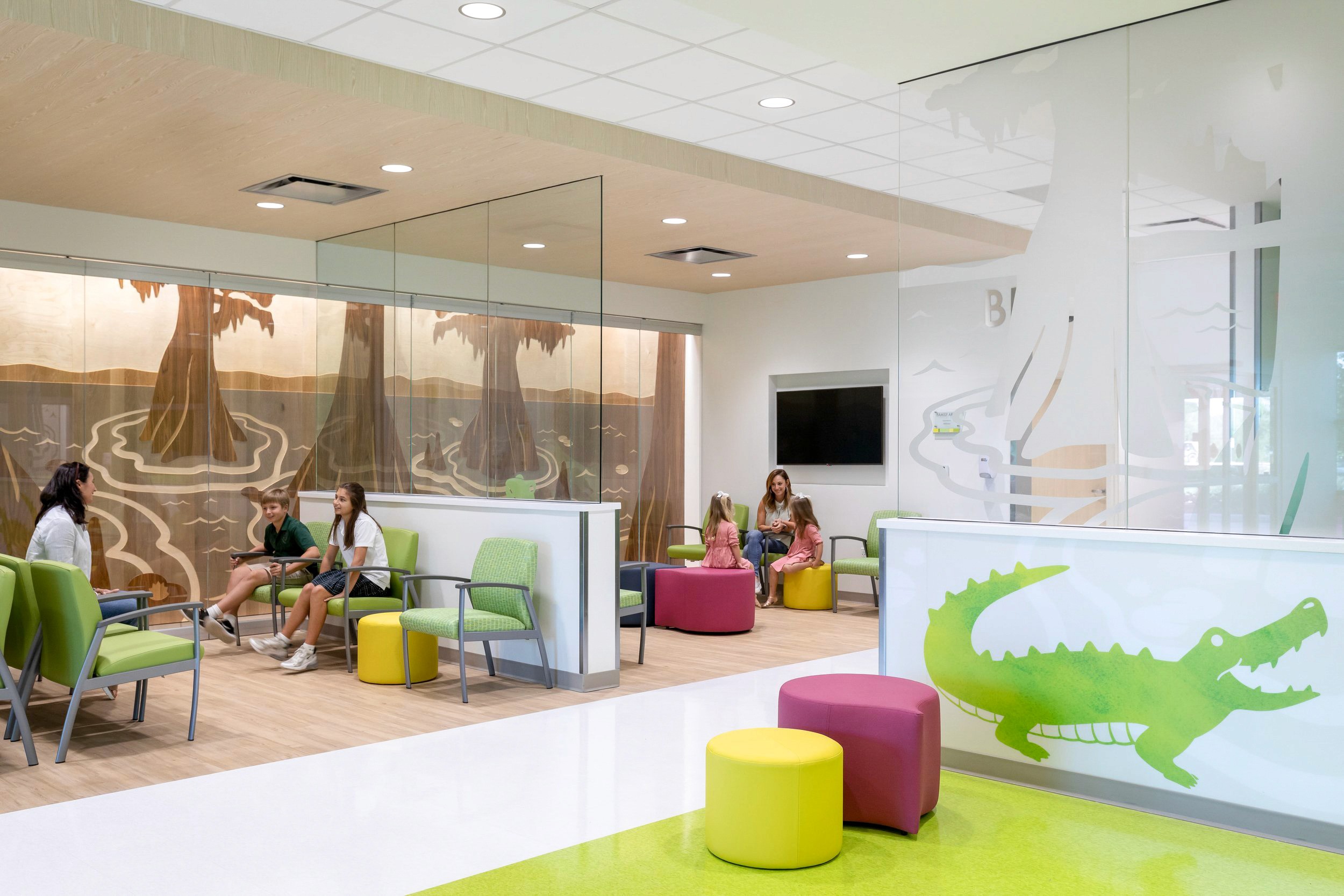 Waiting area with people, green chairs, and alligator art.