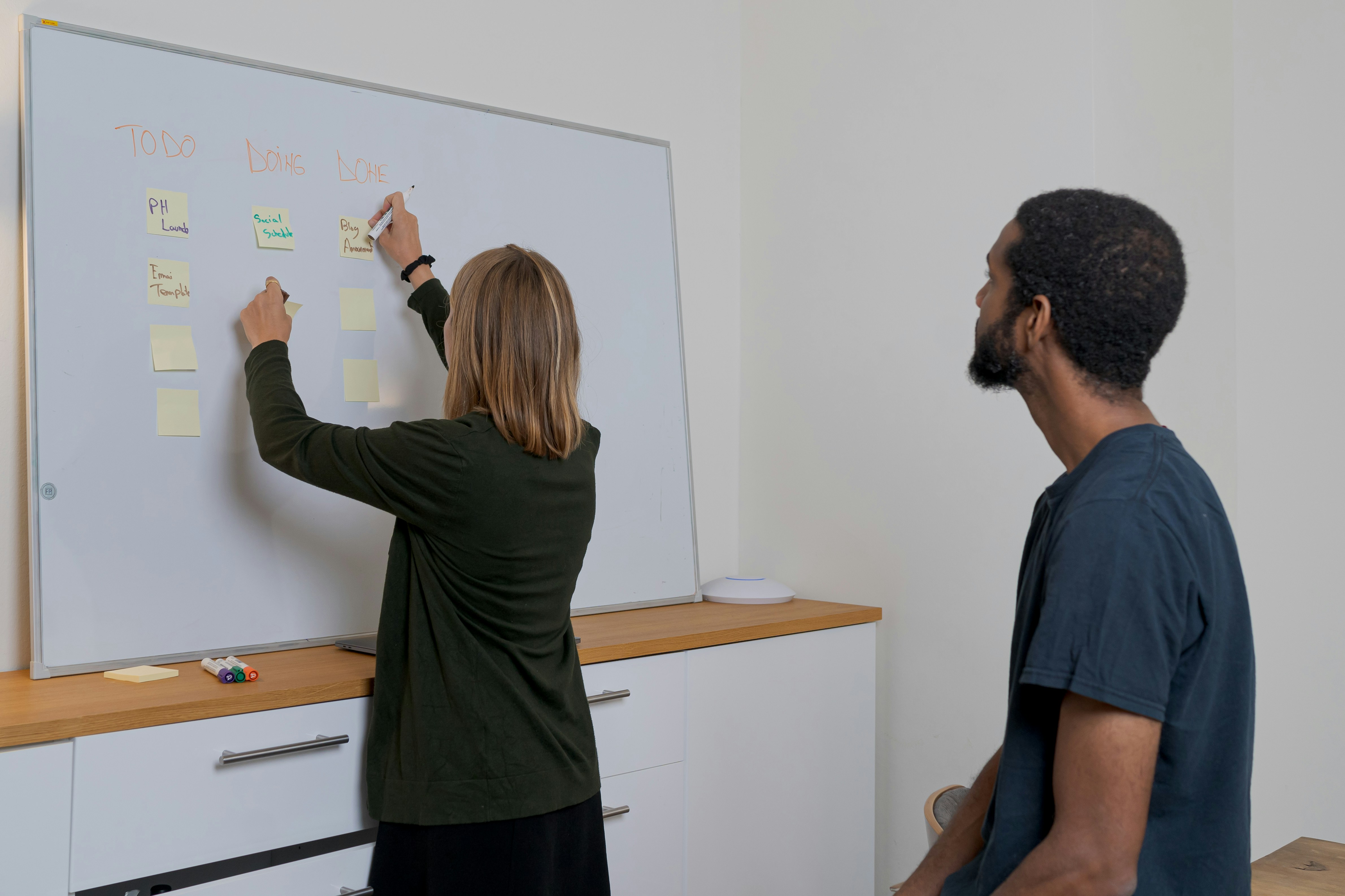 person arranging sticky notes - Sales Funnel Stages