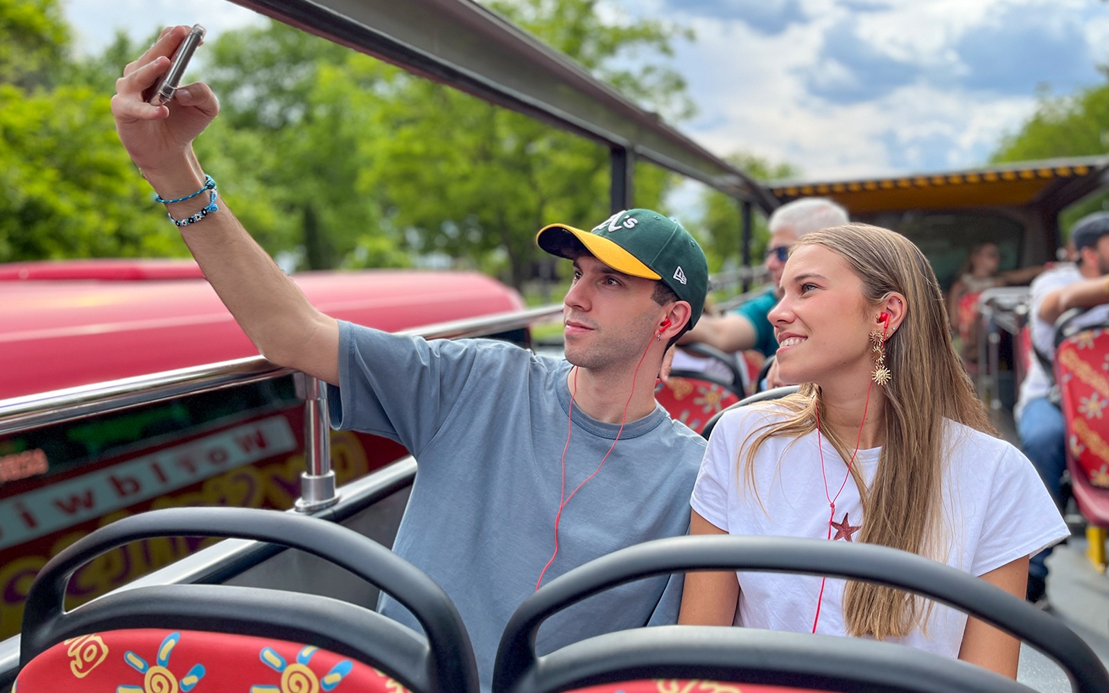 Deux passagers prenant un selfie lors d'un tour en bus à arrêts multiples.