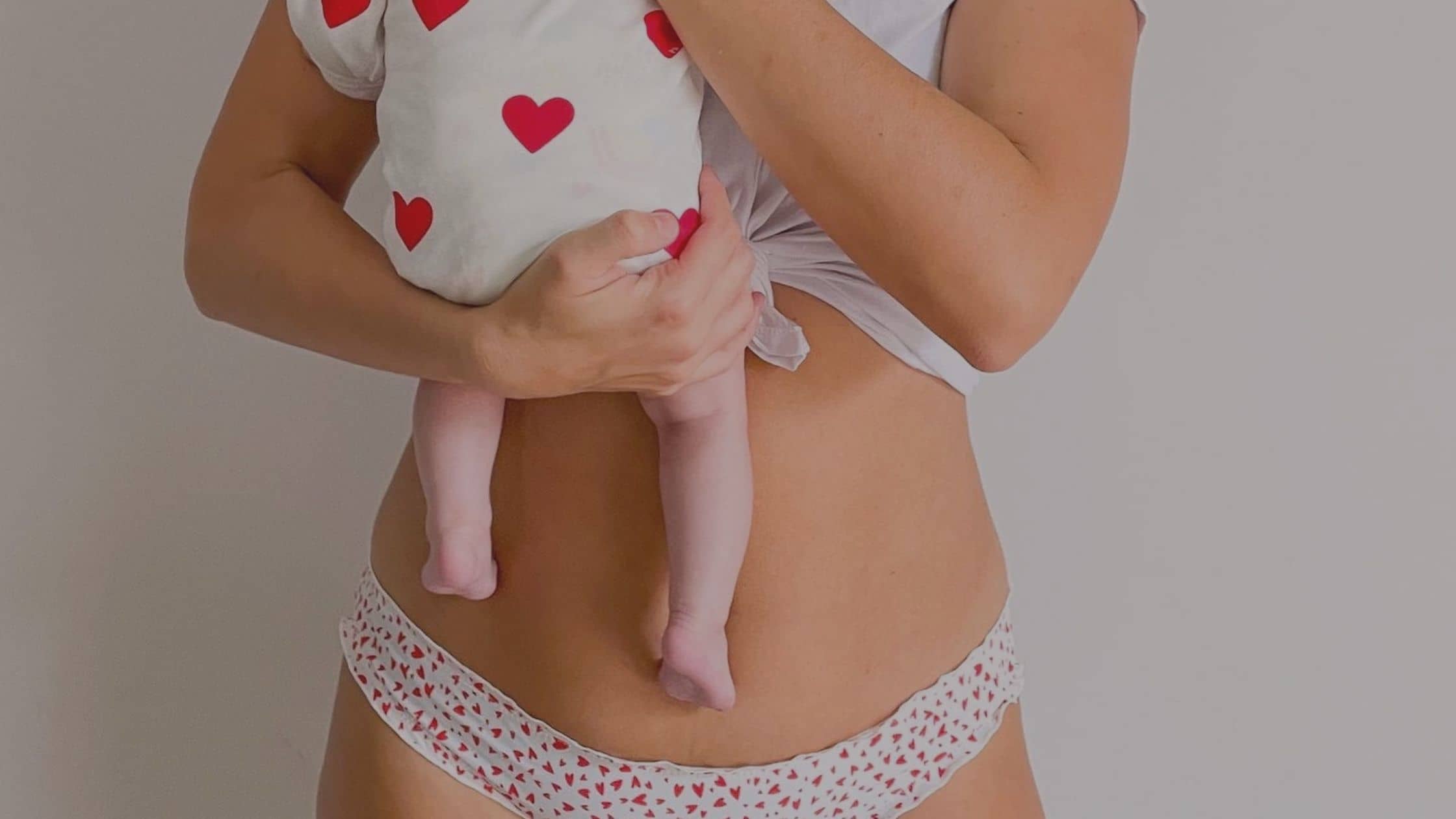 Jeune maman portant son bébé contre son ventre post-partum. Illustration de l'article sur les meilleurs conseils et exercices pour perdre le ventre de grossesse sainement.