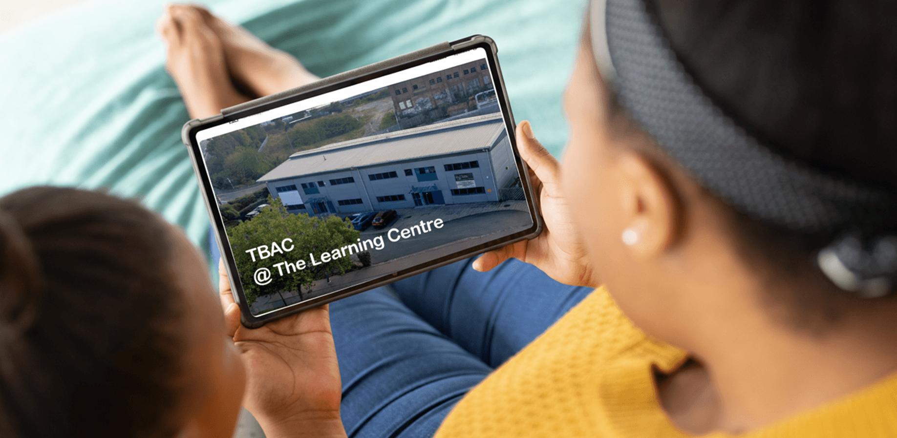 A mother and her daughter viewing the TBAC website on a tablet. 