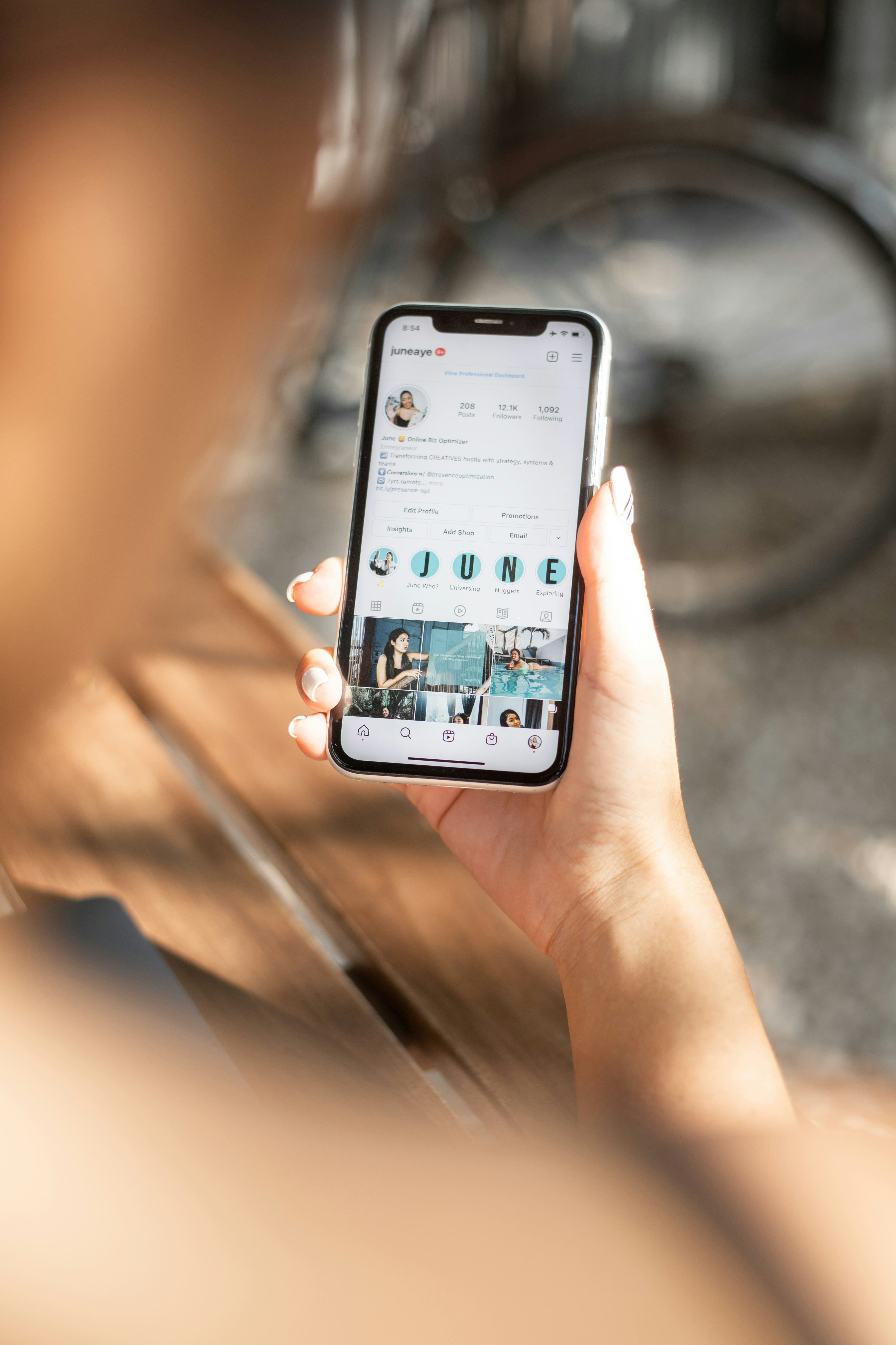 Close-up of a phone showcasing a woman going through a Instagram page. 