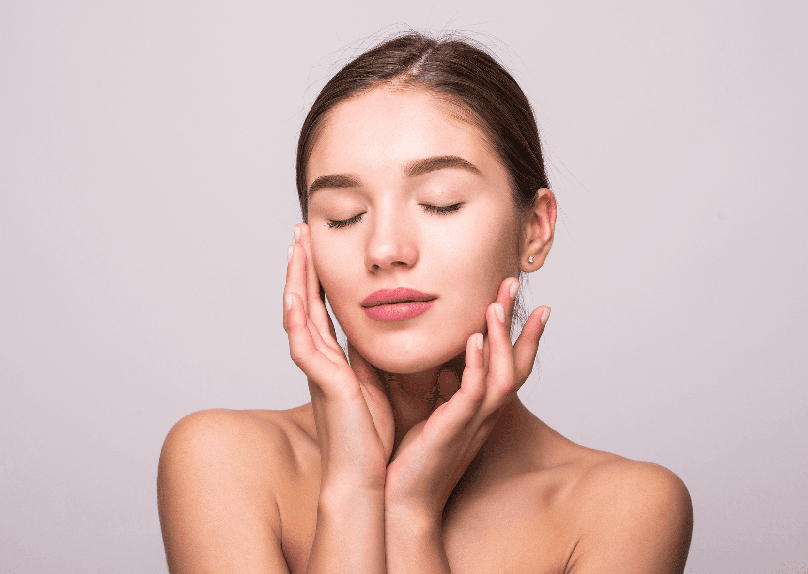 Smiling woman with cream on her cheek.