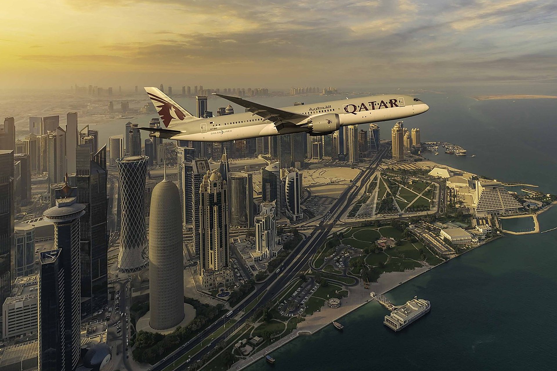 Un avion de Qatar Airways, la compagnie élue 9 fois meilleure du monde, en vol au-dessus des tours de West Bay, à Doha