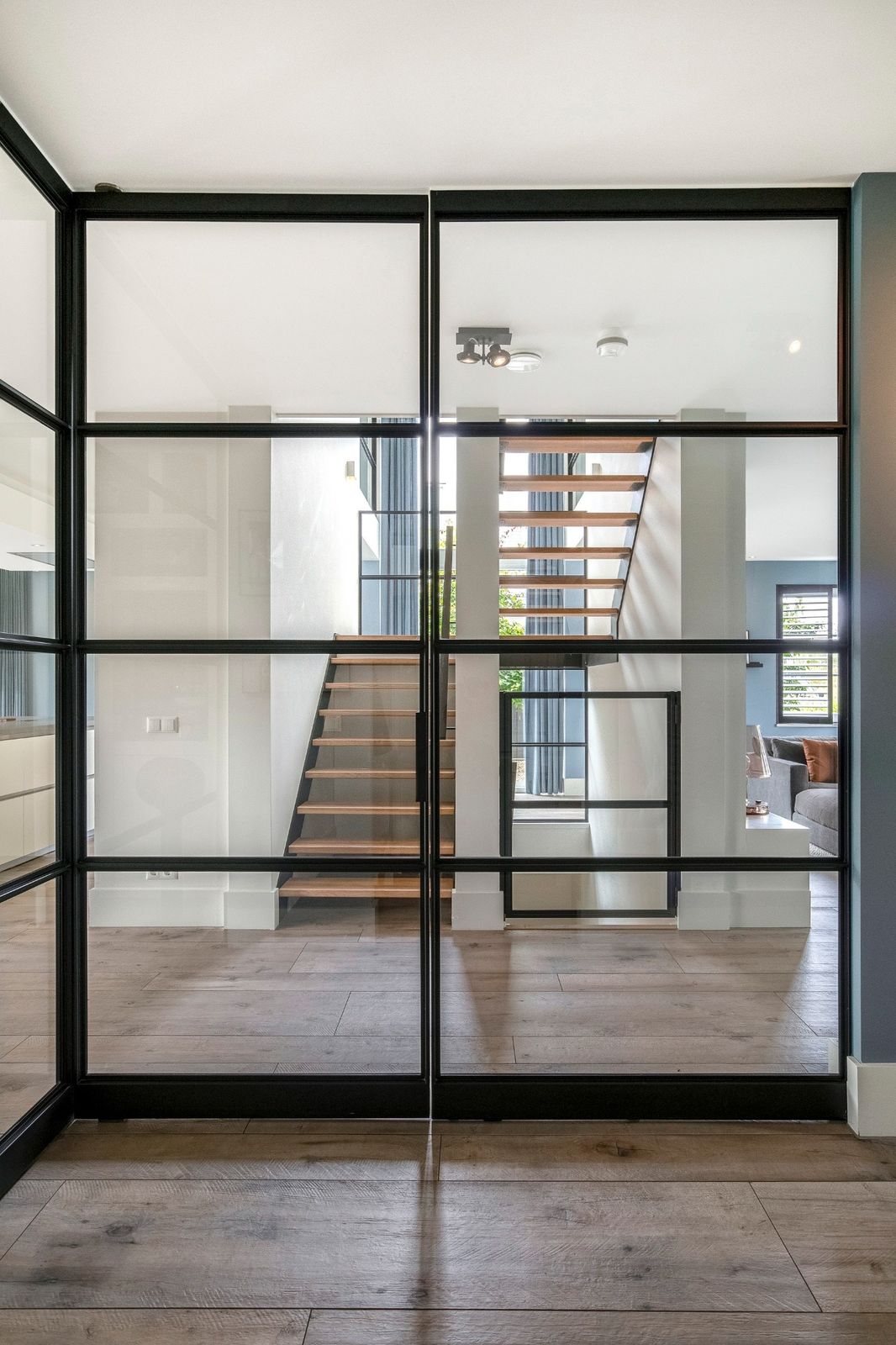 glazen pui hal naar woonkamer, zwart staal