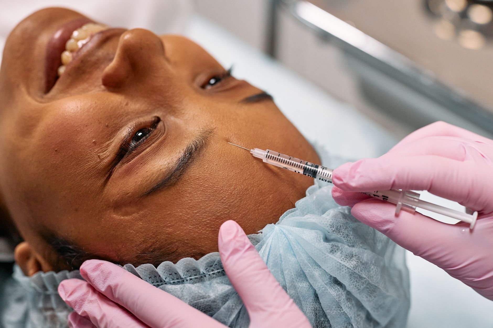 Aesthetics provider performing gentle facial treatment preparation on client in Roseville clinic