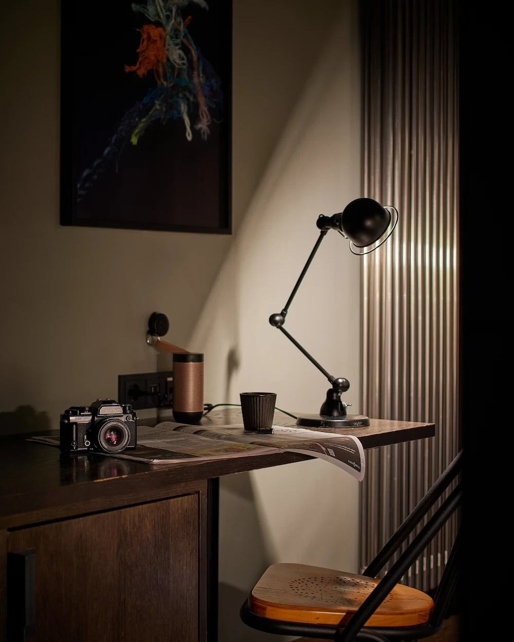 Work desk with camera, task lamp, coffee cup, and city guide.