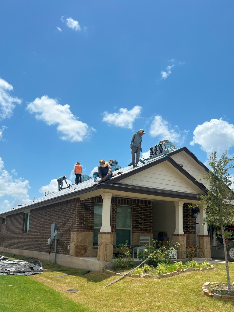 Two roofers at work. Nailing wooden battens on the roof with carpenter hammer or electric nailer