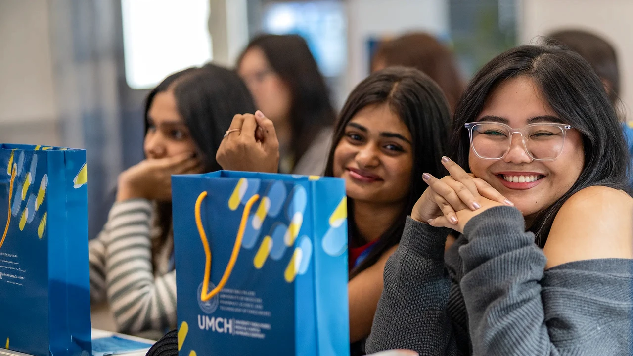 Smilende studenter på første dag med velkomstposene fra universitetet